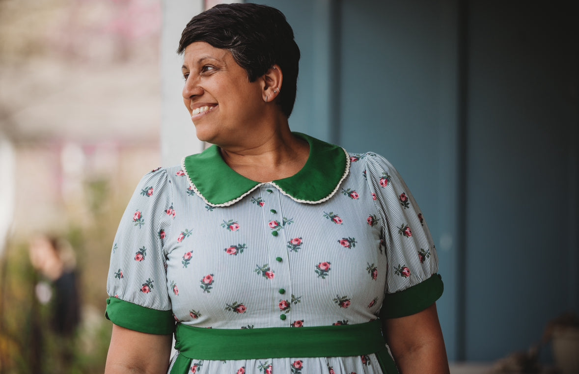 woman wearing a green and white striped modest nursing dress