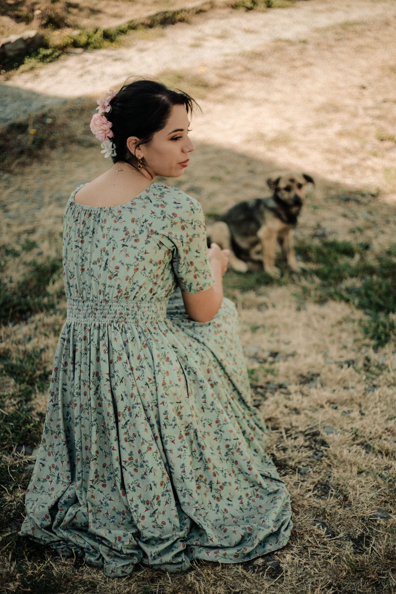 Woman in modest nursing floral dress with dog outdoors