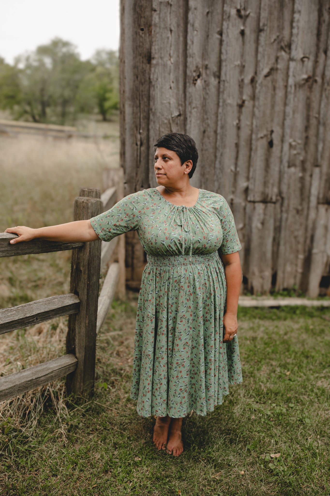 Woman in modest nursing dress by fence