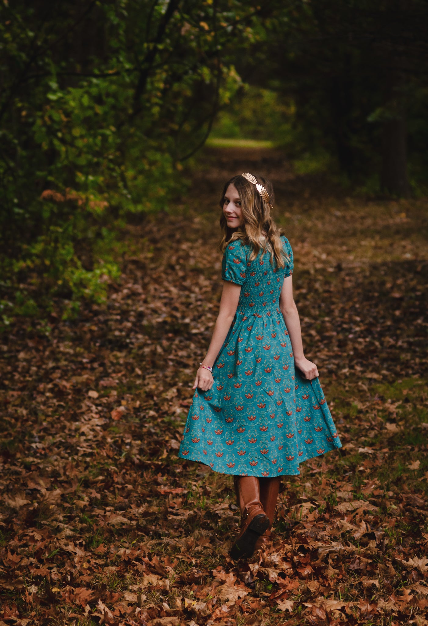Woman wearing modest nursing dress walking through forest.