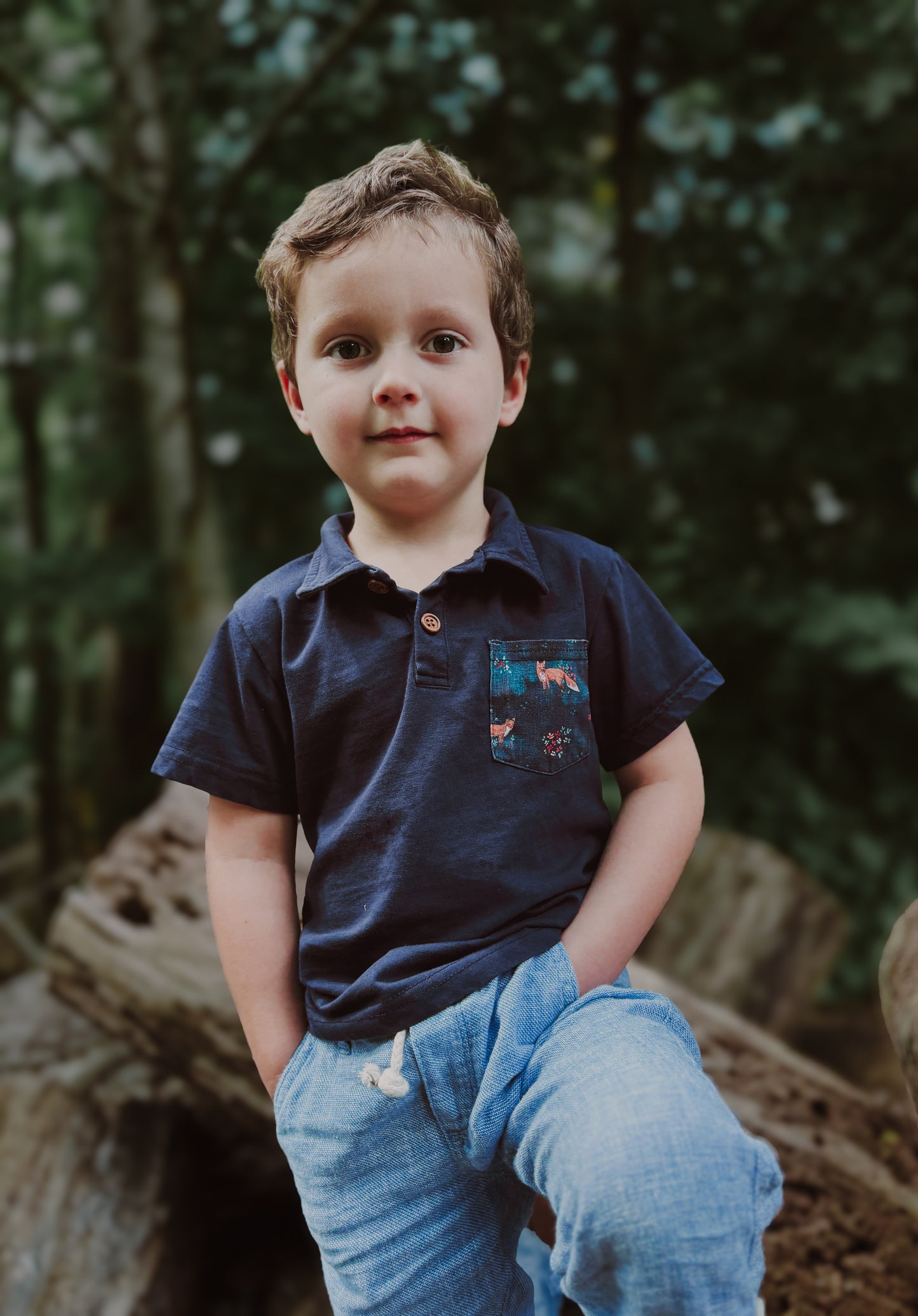 Boy in navy polo outdoors.