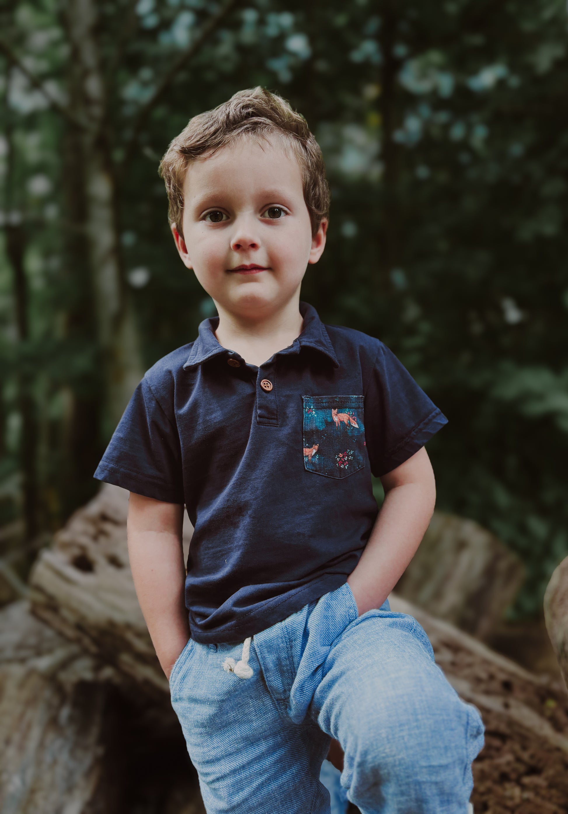 Boy in navy polo outdoors.