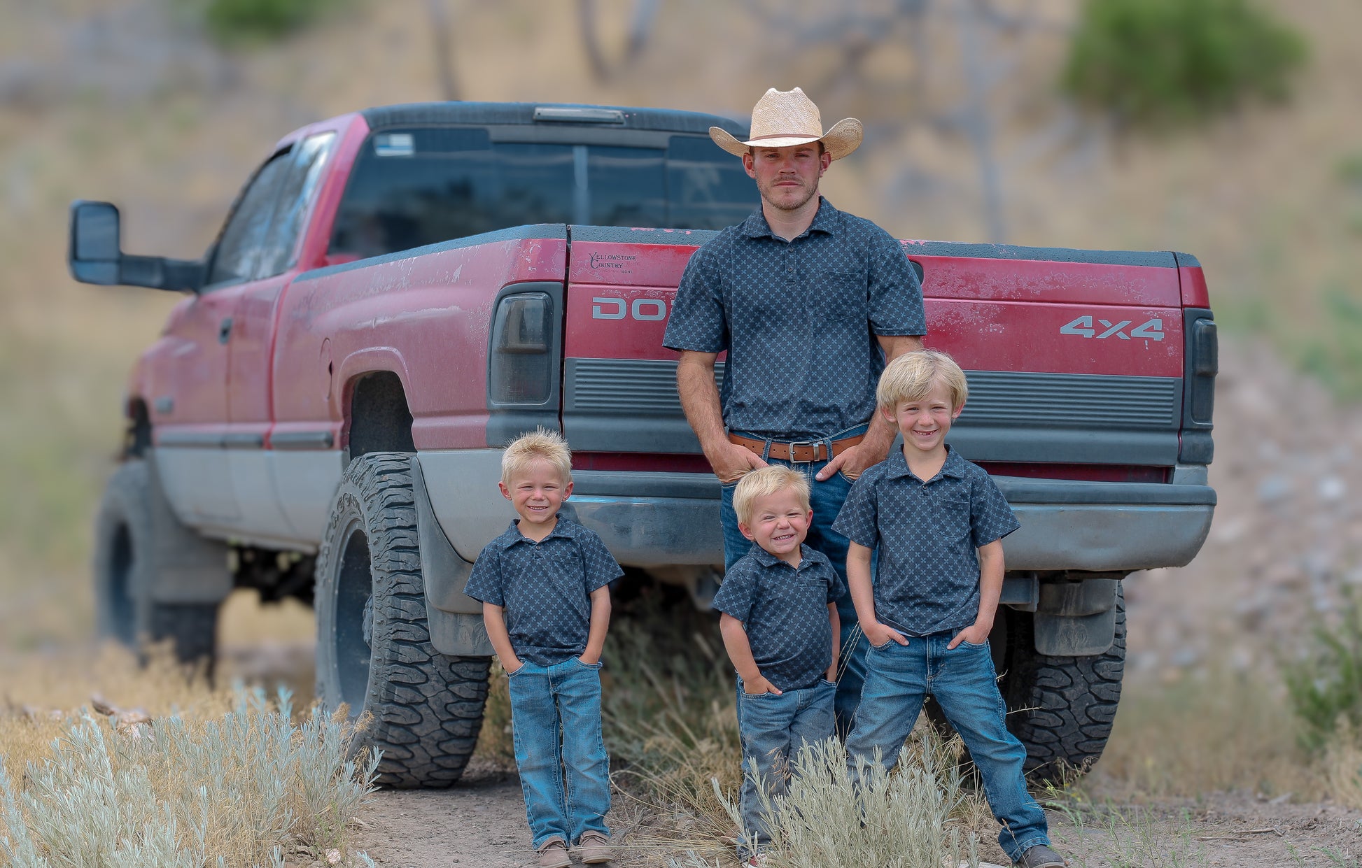 Young boys wearing a dark blue polo shirt with their father in a matching shirt
