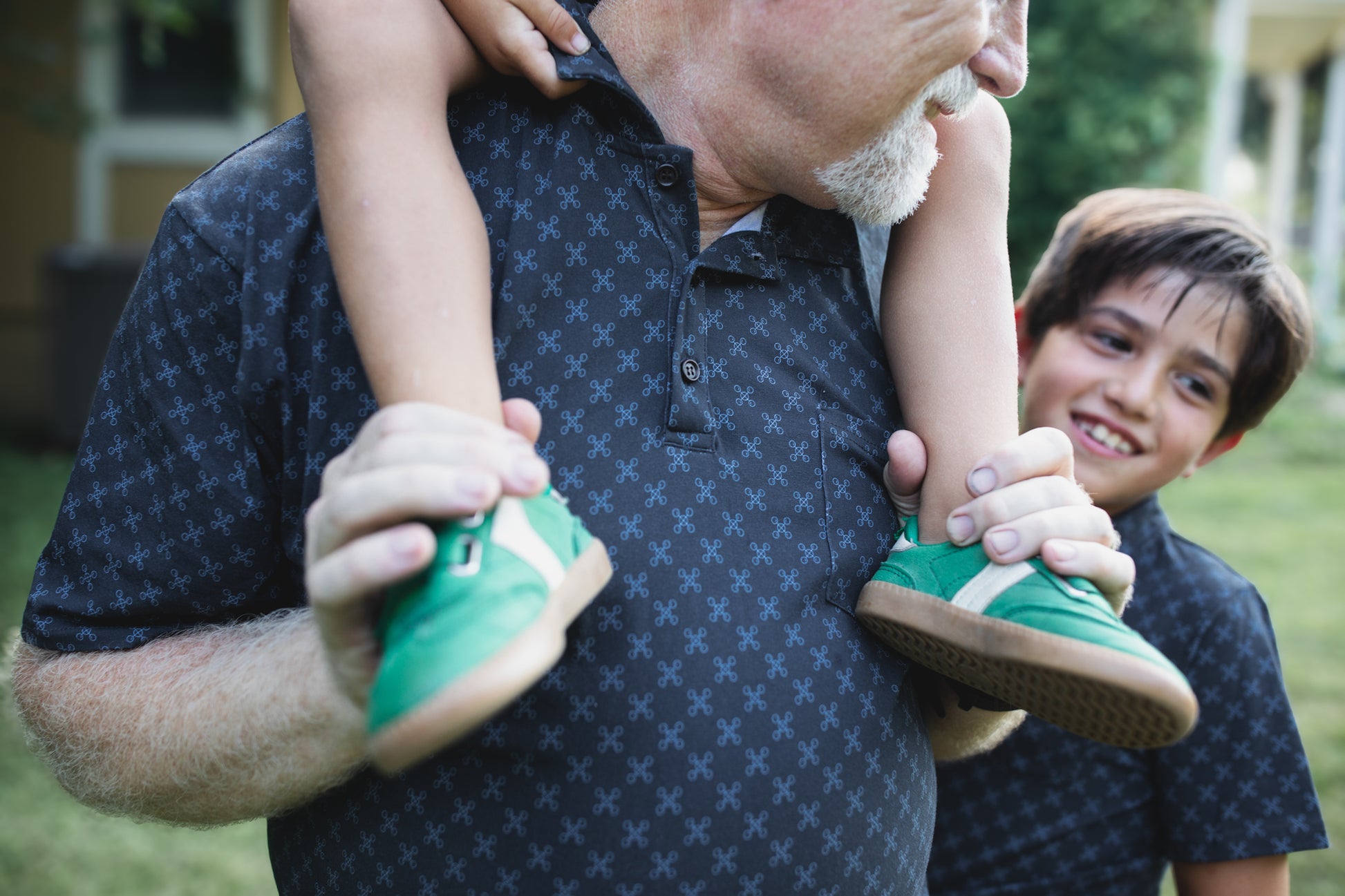 Young boys wearing dark blue polo shirts with their father in a matching shirt