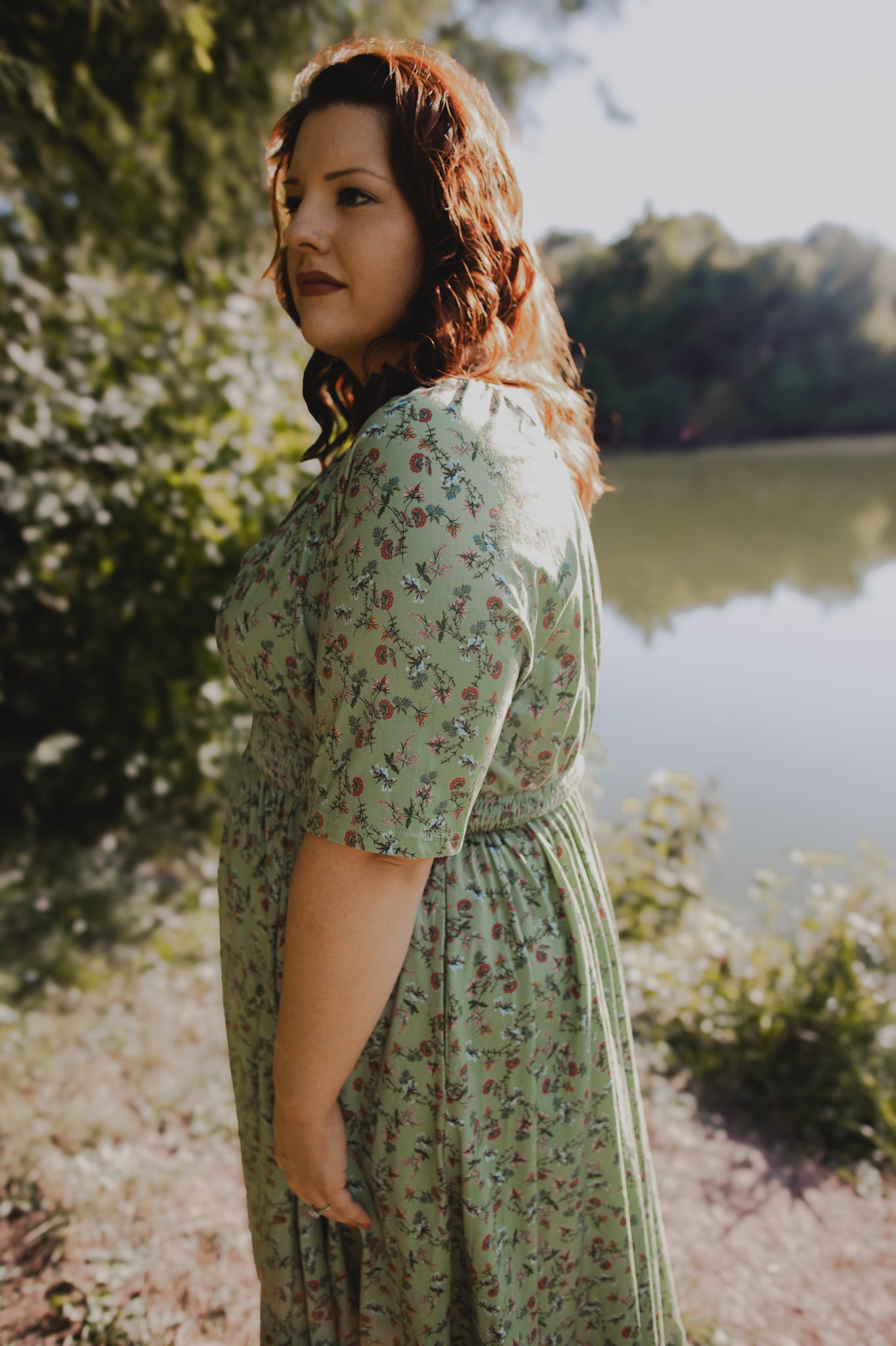 Woman in modest nursing floral dress by lake