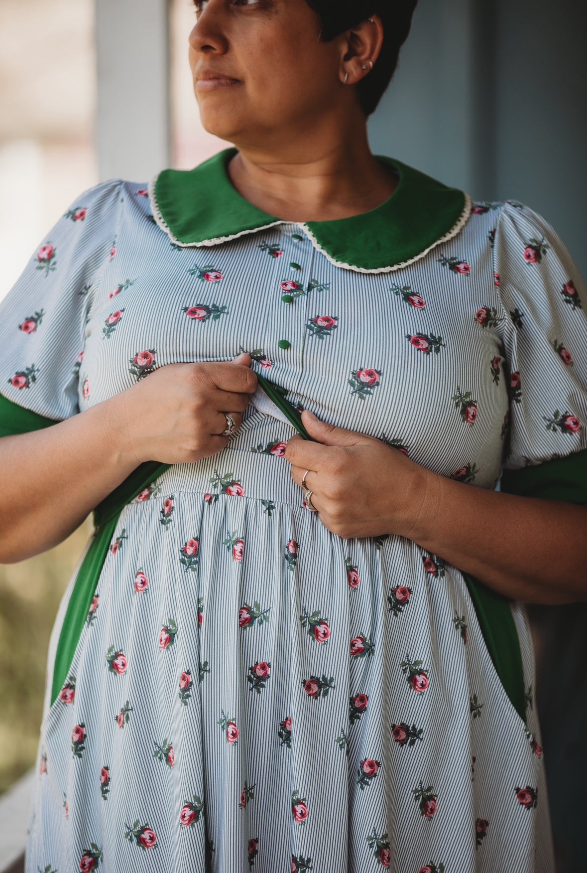 woman wearing a green and white striped modest nursing dress