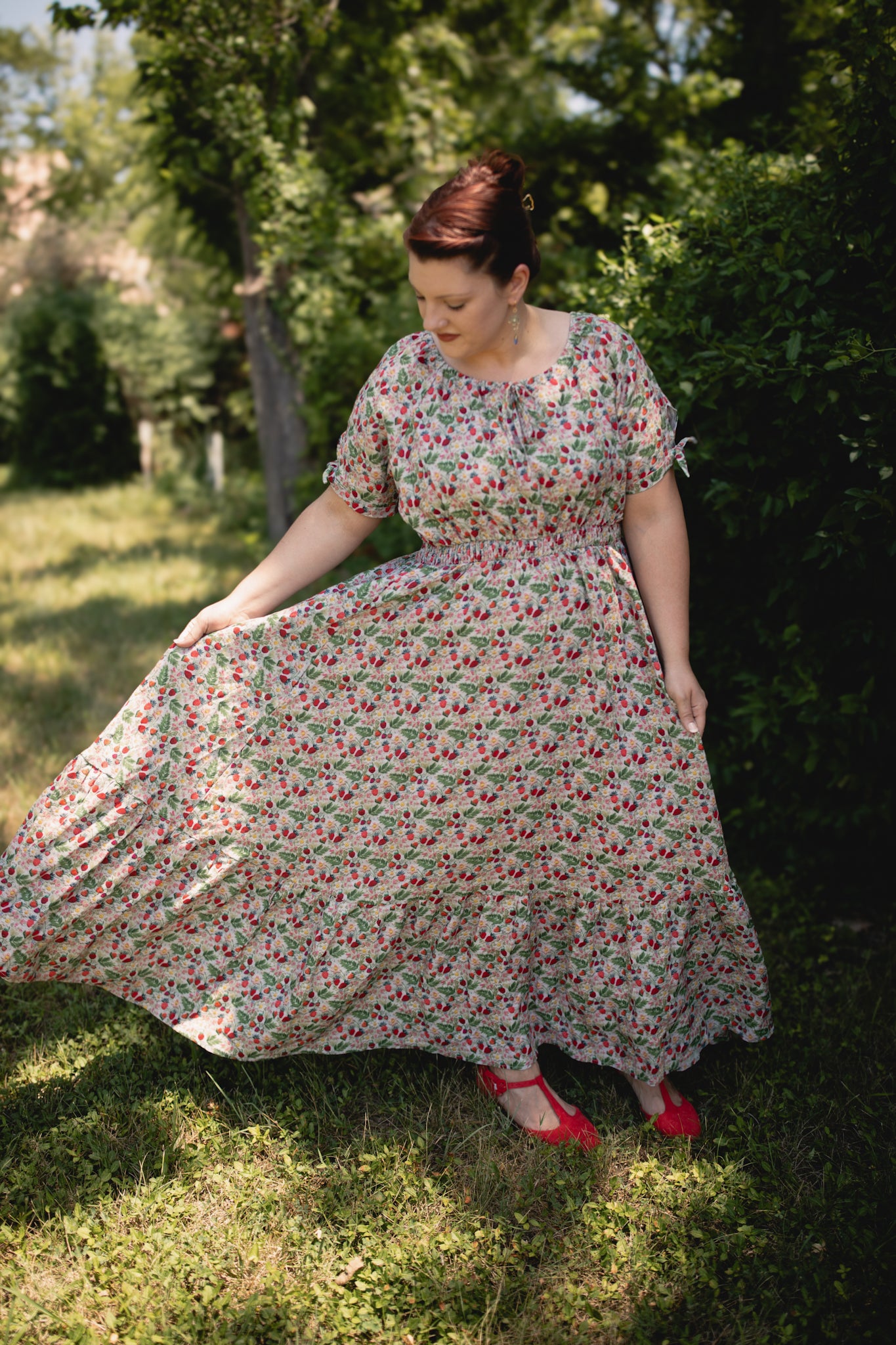 Woman in a floral modest nursing dress standing outdoors in a garden