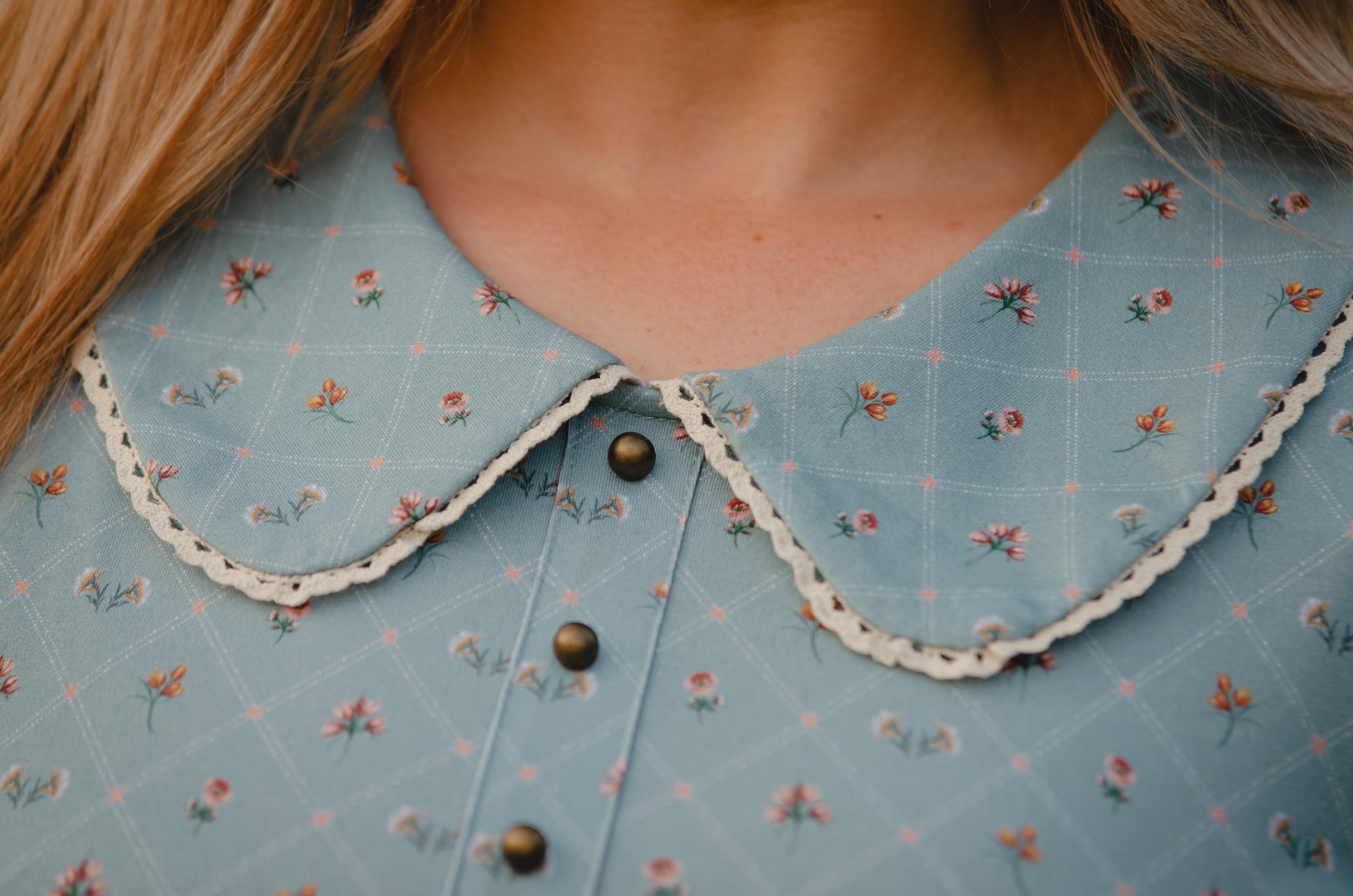 Close-up of a blue floral-patterned modest nursing dress collar with buttons.