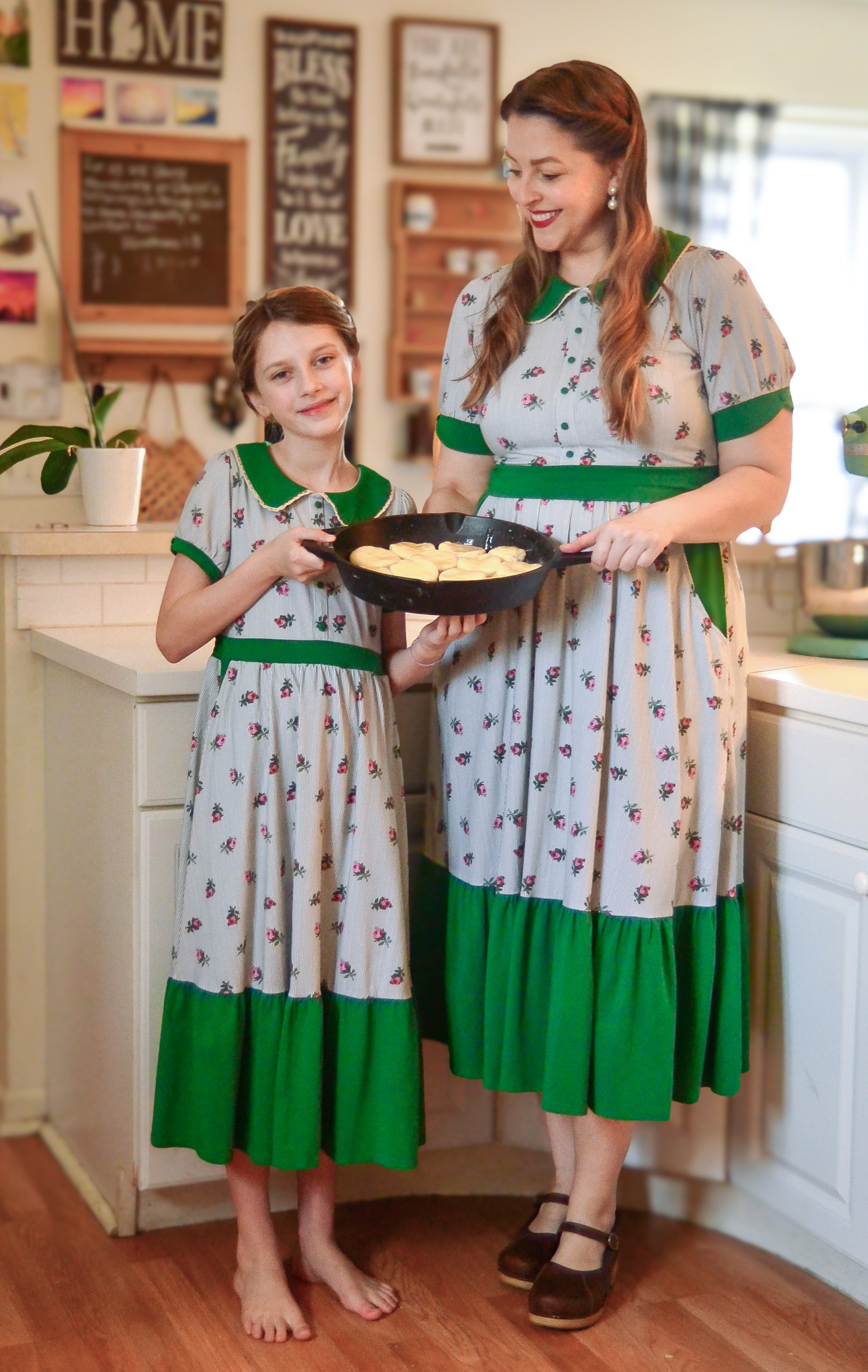 woman wearing a green and white striped modest nursing dress with her daughter wearing a matching dress