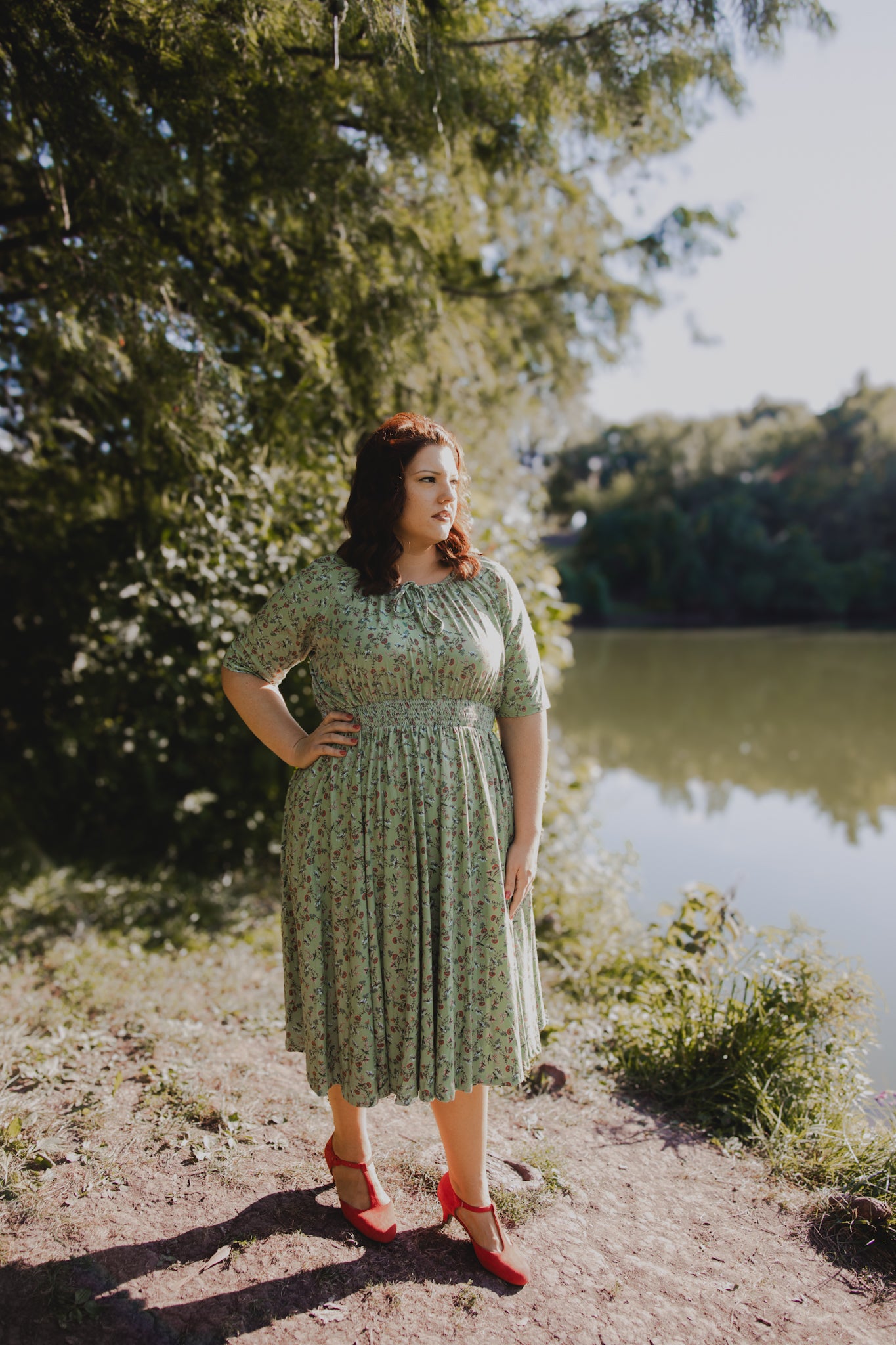 Woman in modest nursing dress by lake