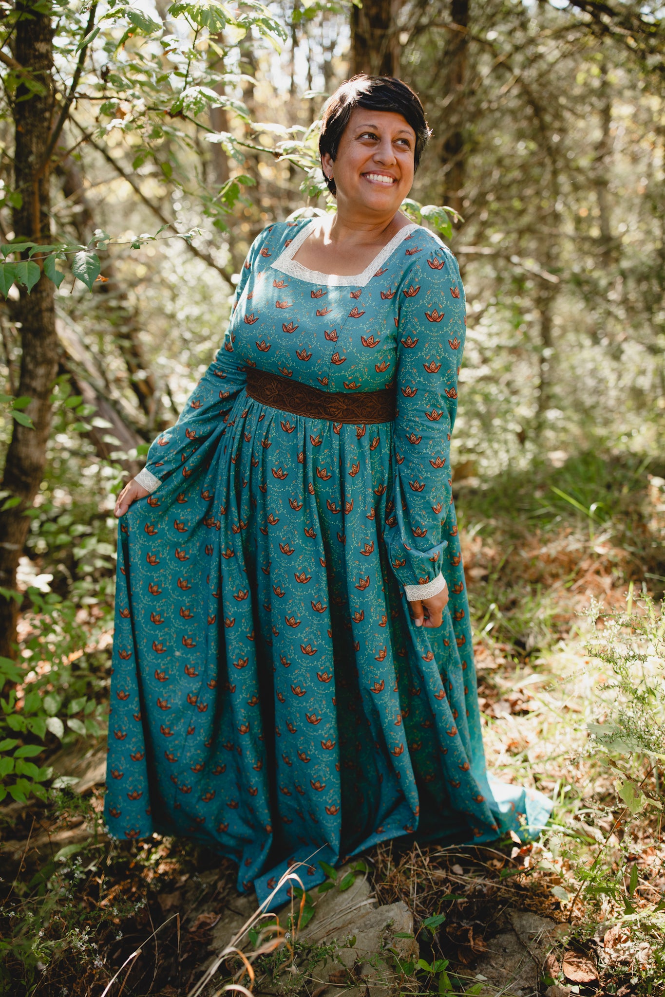 Woman in modest nursing teal patterned dress in forest