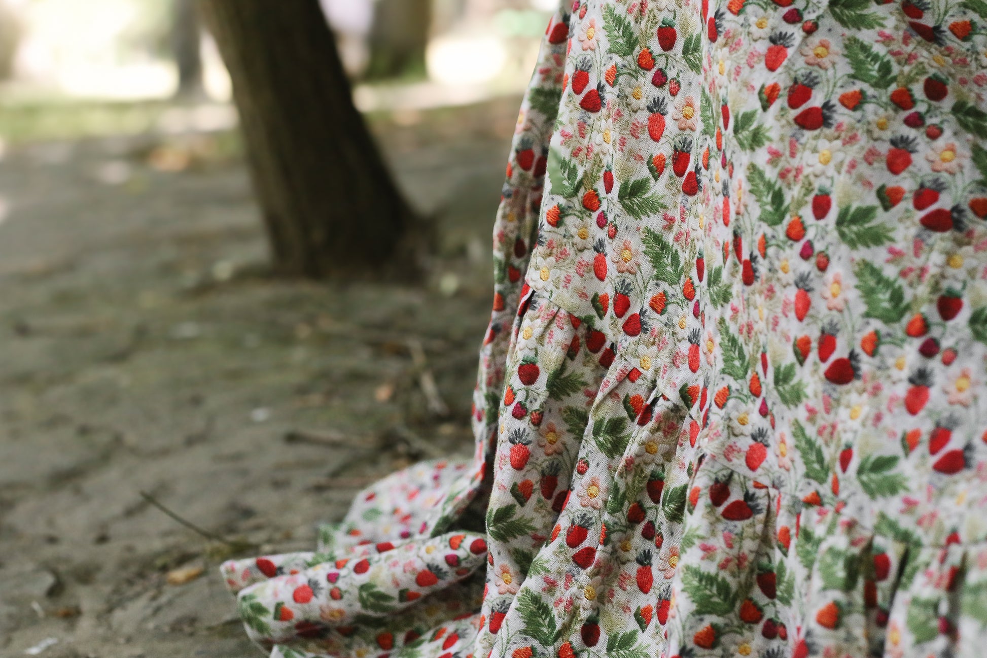 Floral fabric with red and green pattern on a blurred natural background