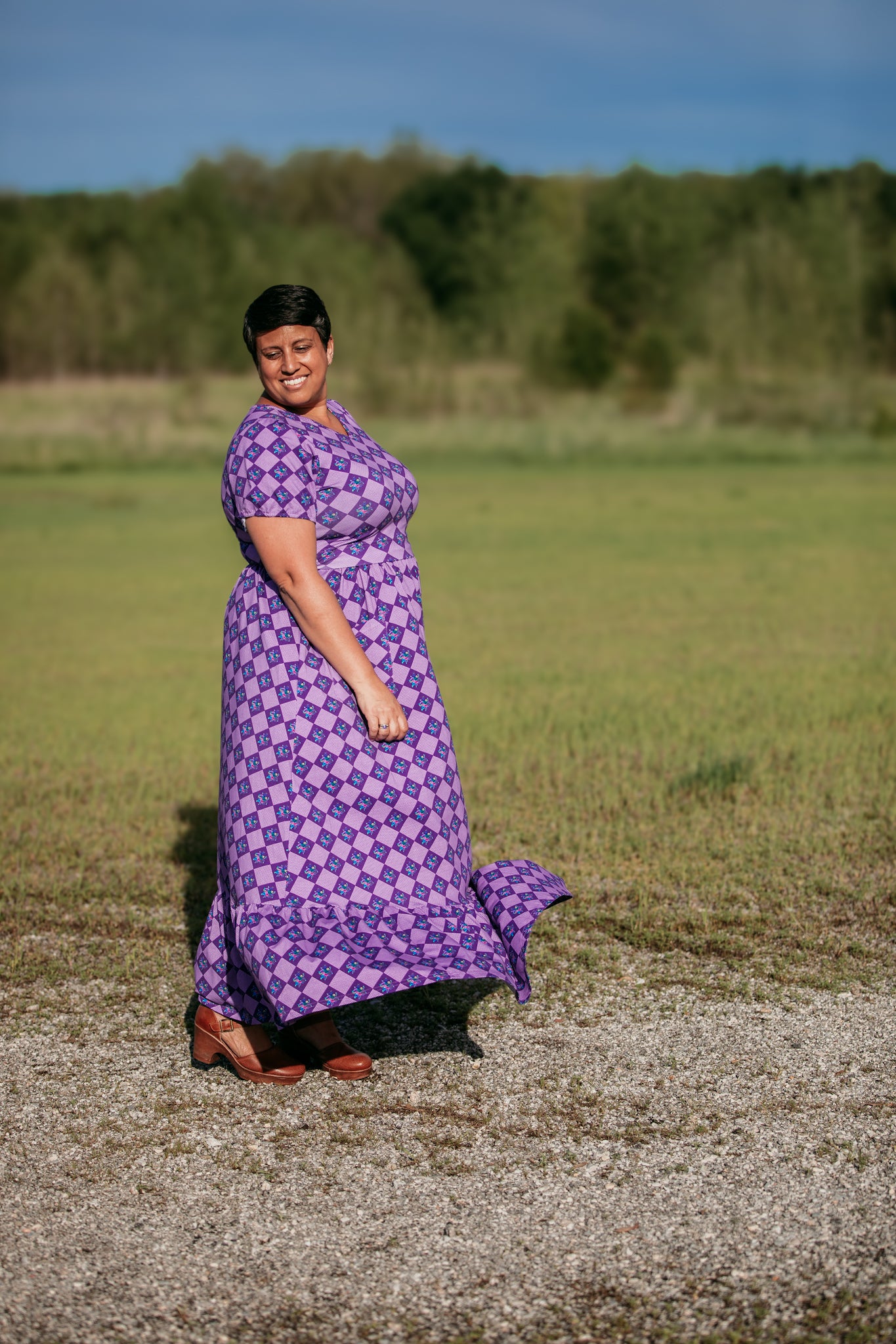 Woman in a purple checkered modest nursing dress.