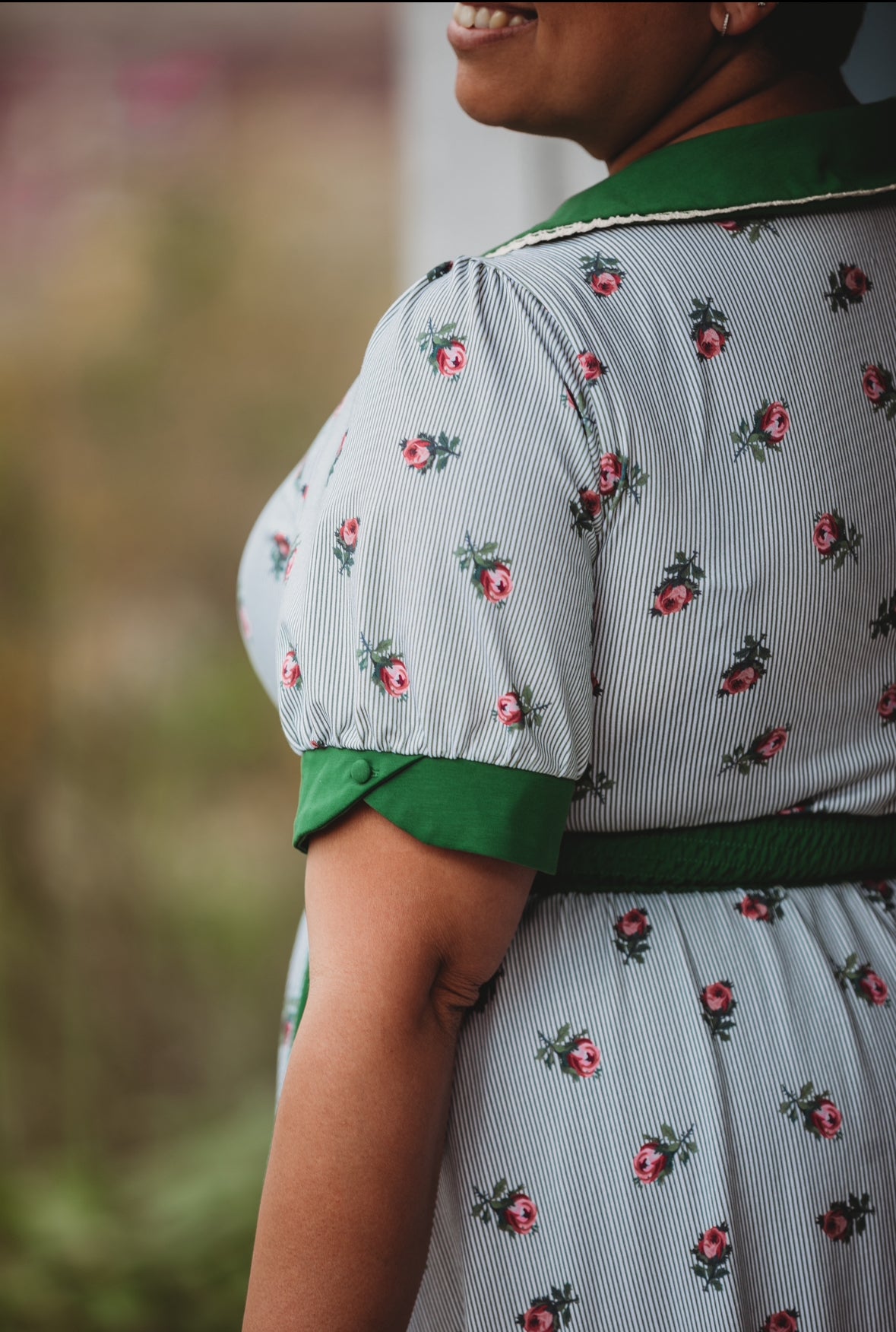 woman wearing a green and white striped modest nursing dress