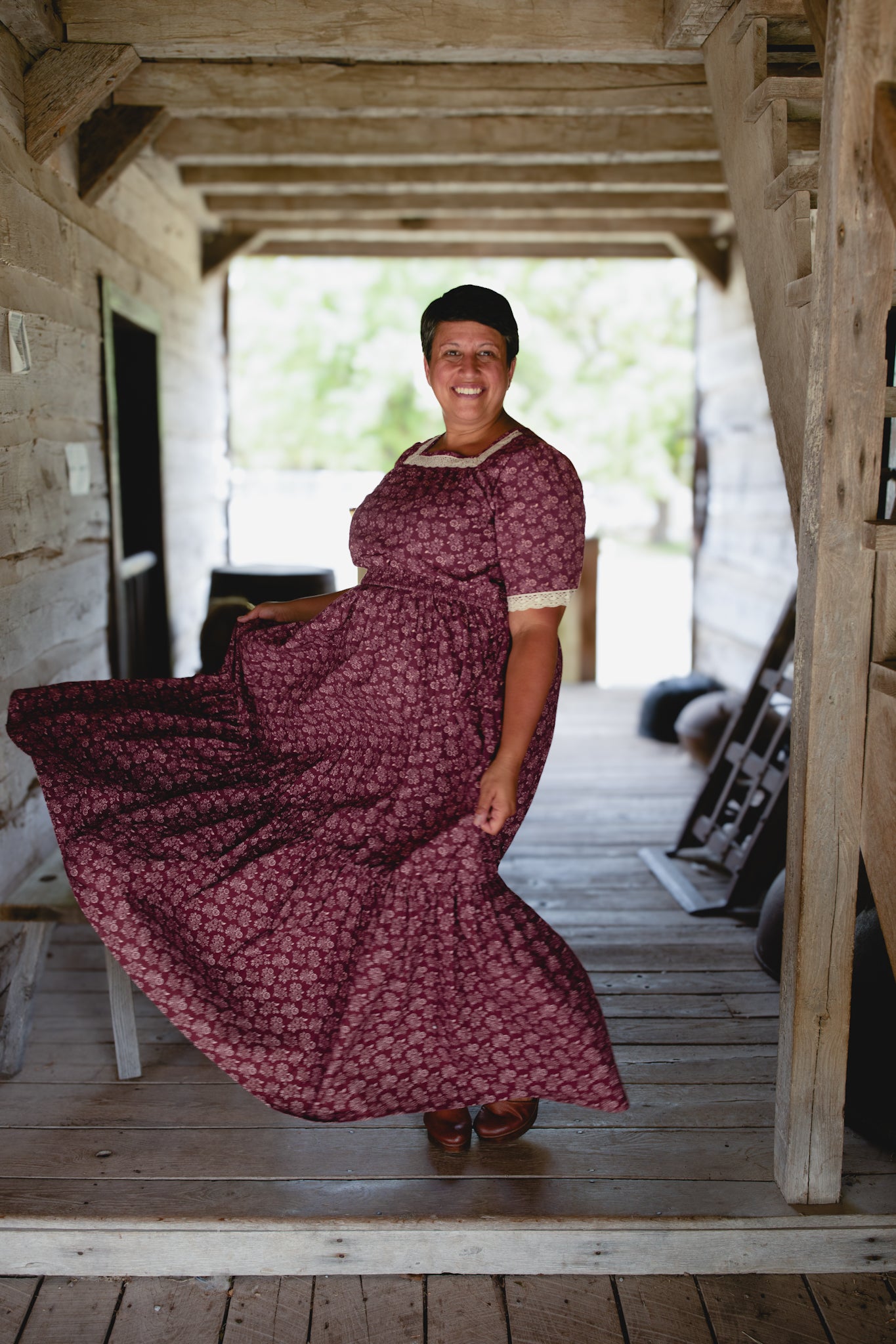 Woman in modest burgundy nursing dress indoors