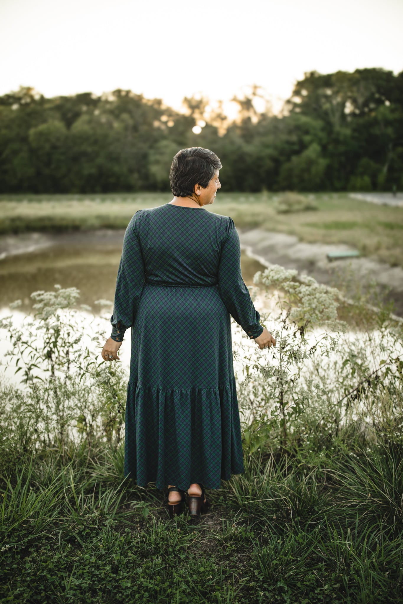 Woman in modest nursing green dress by water