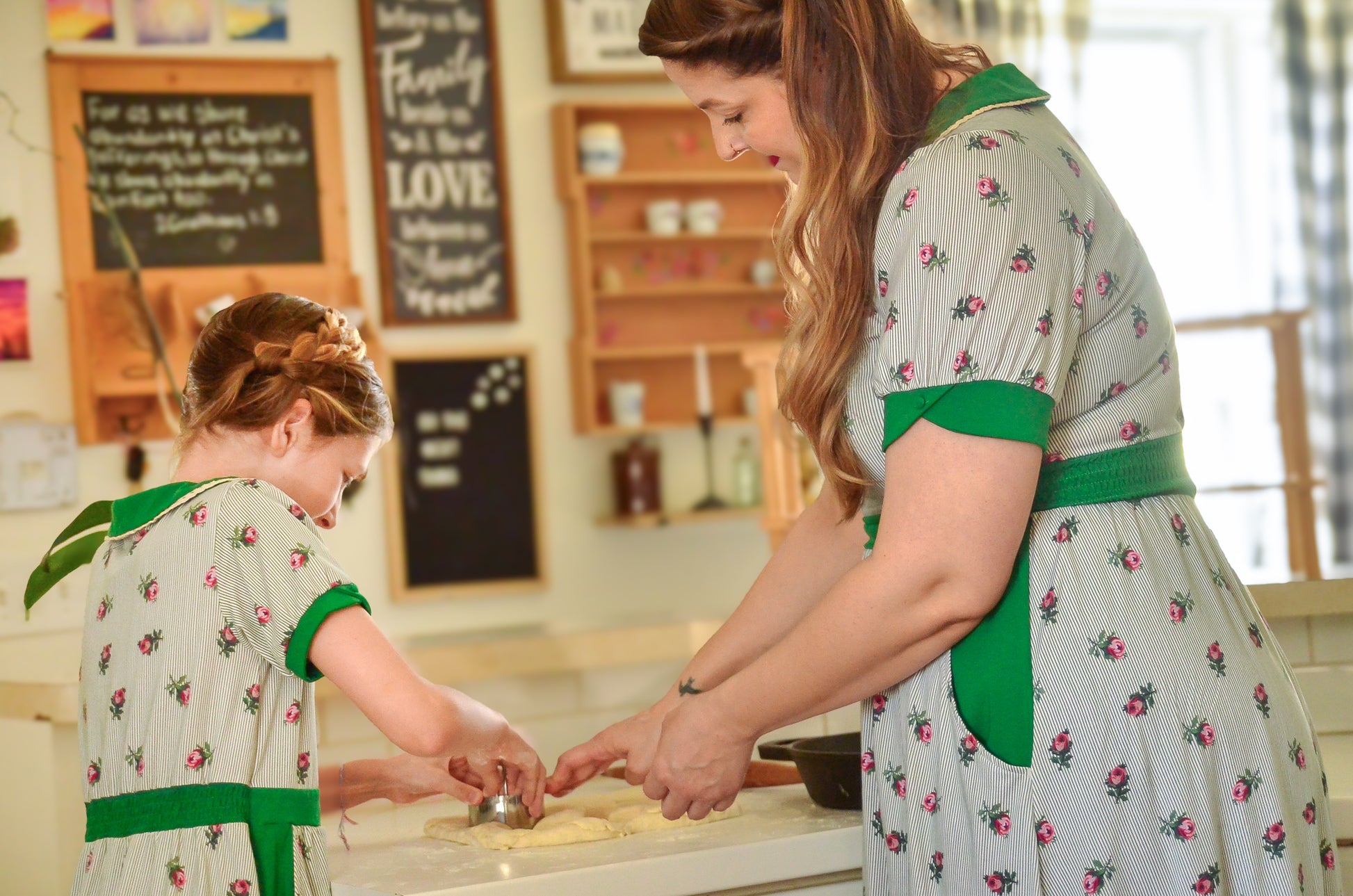 woman wearing a green and white striped modest nursing dress with her daughter wearing a matching dress