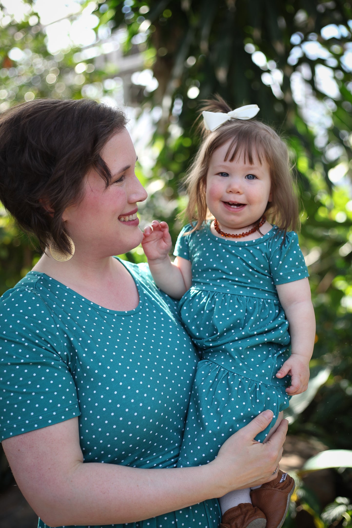 woman wearing modest nursing dress with her baby in hand with a matching dress