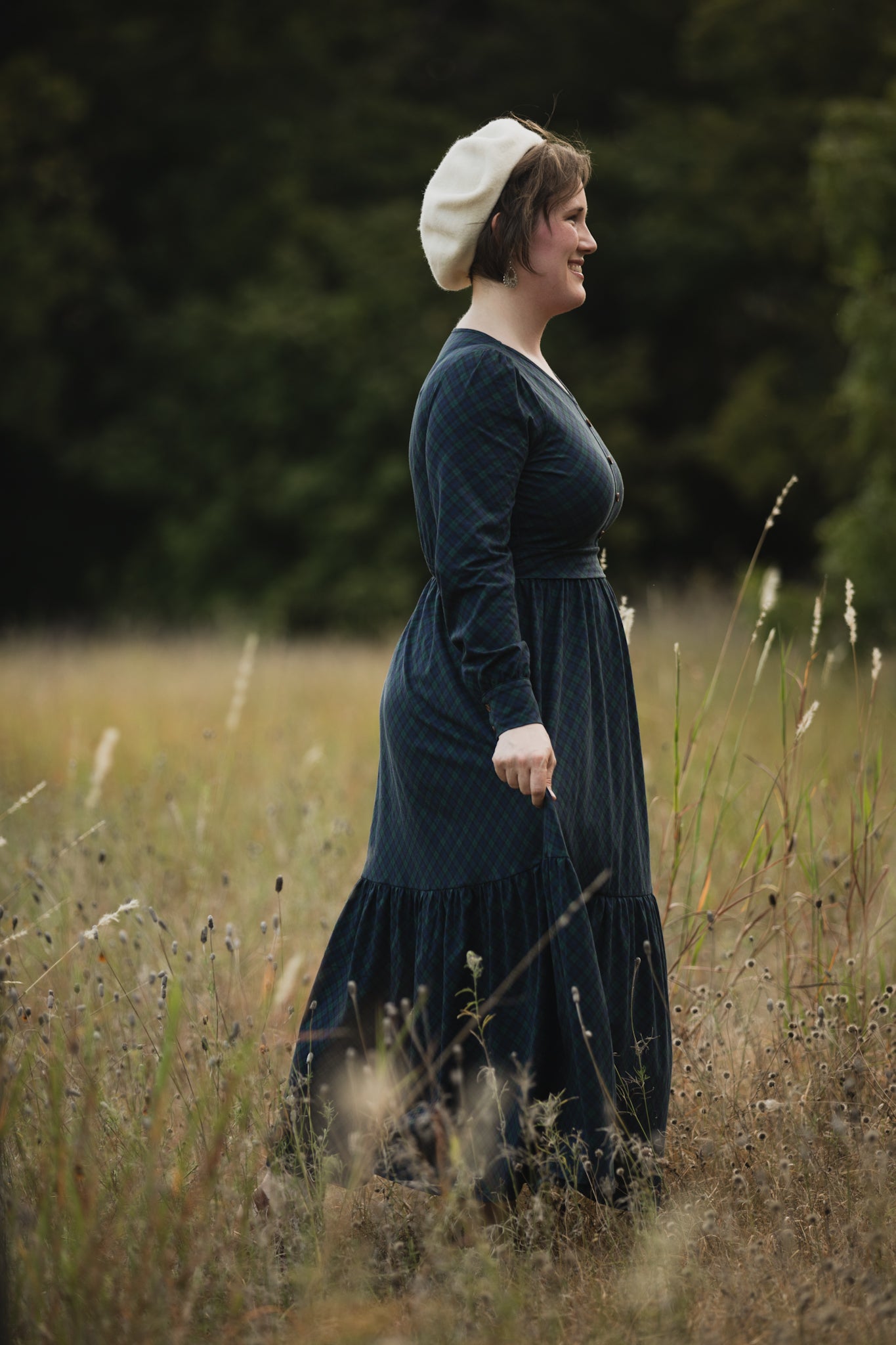 Woman in modest nursing dark dress white headscarf field