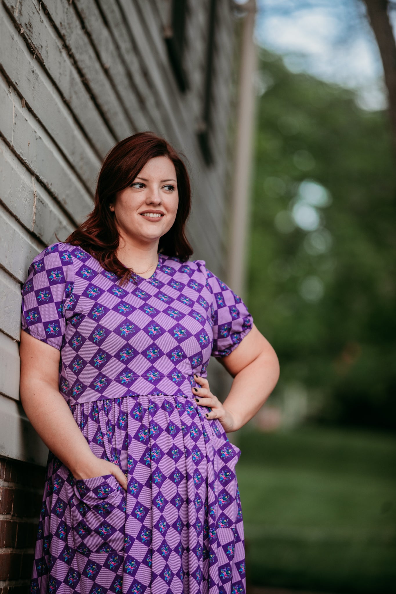 Woman in a purple checkered modest nursing dress.