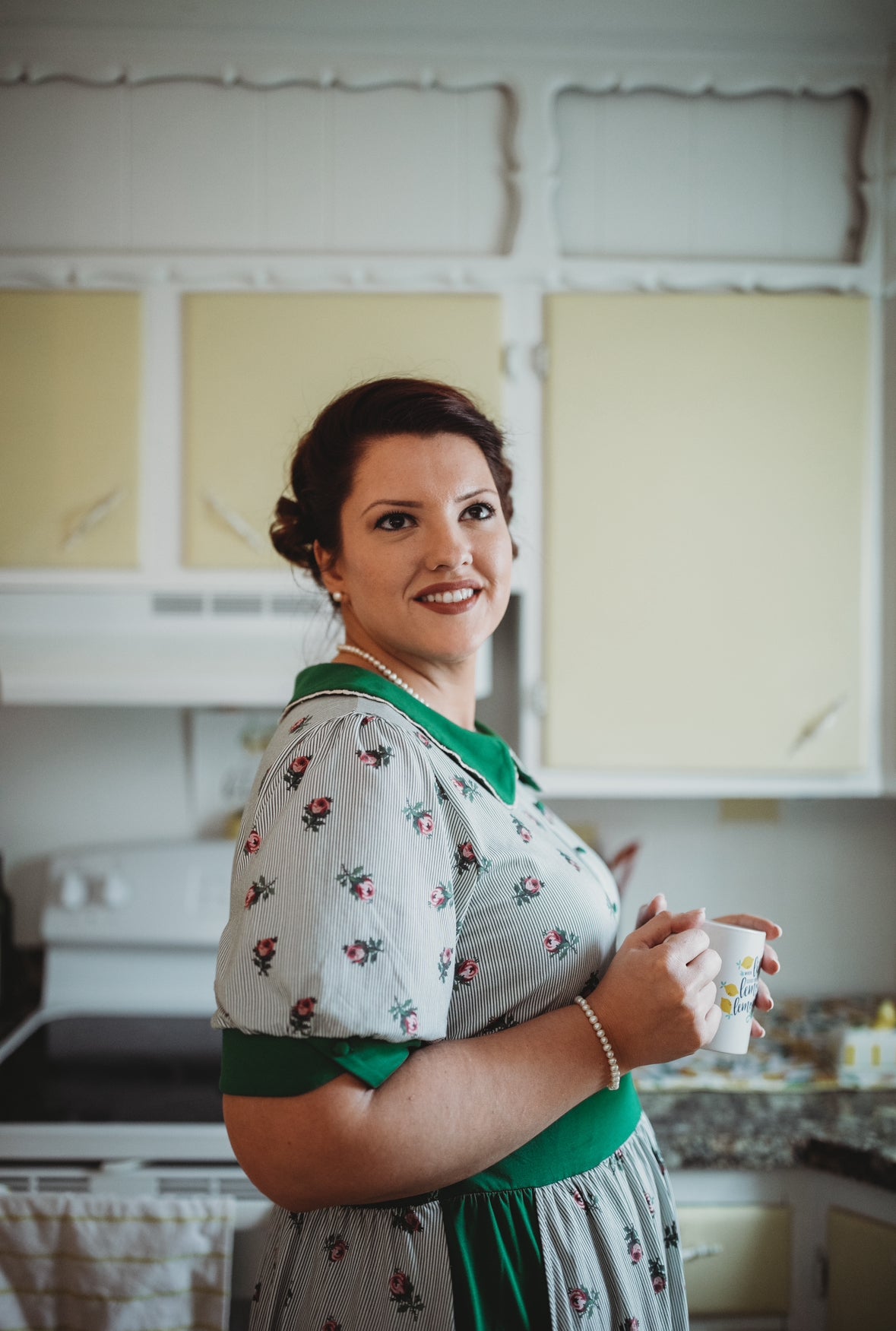woman wearing a green and white striped modest nursing dress