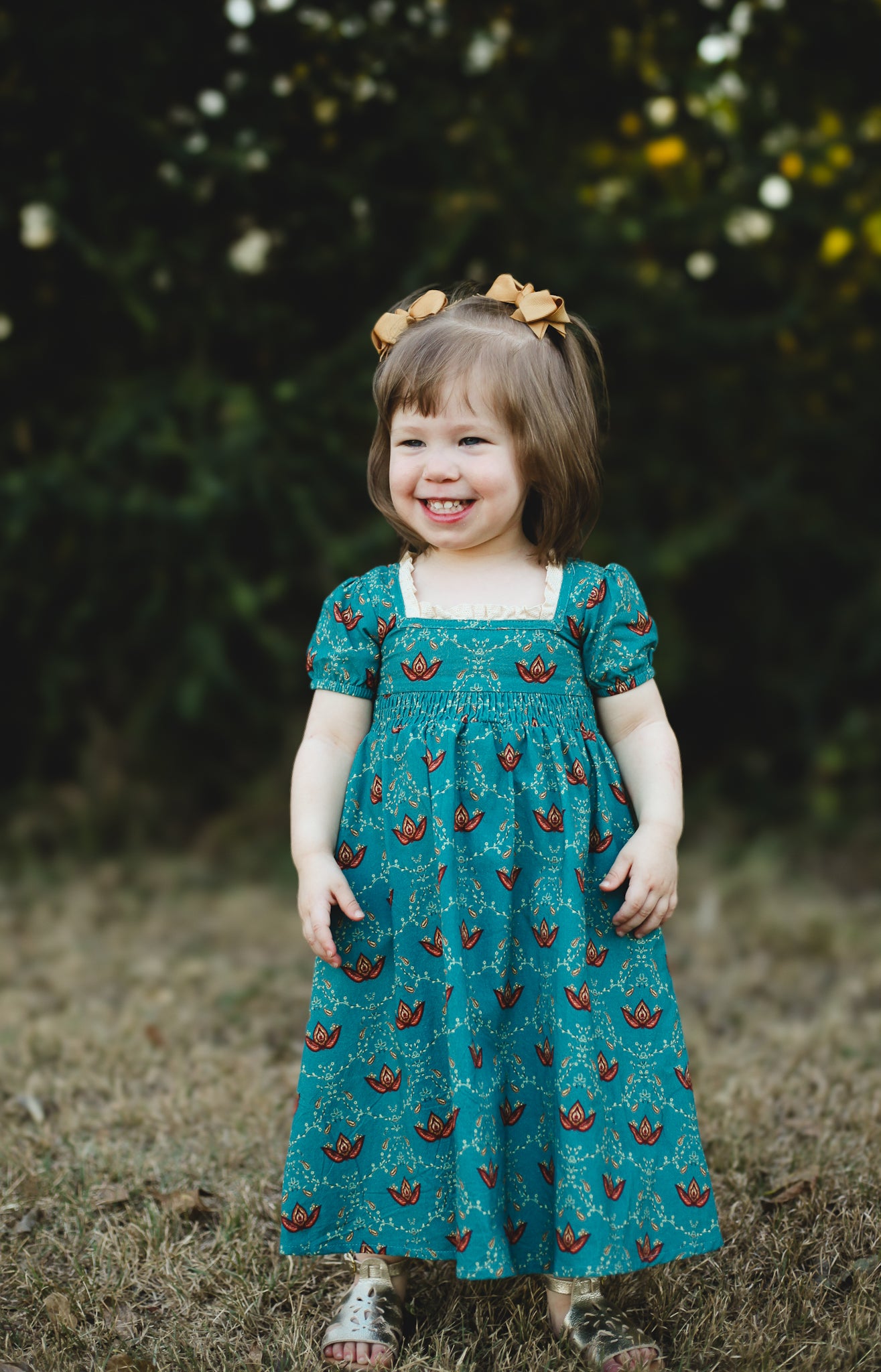 Young girl wearing modest teal dress with butterflies