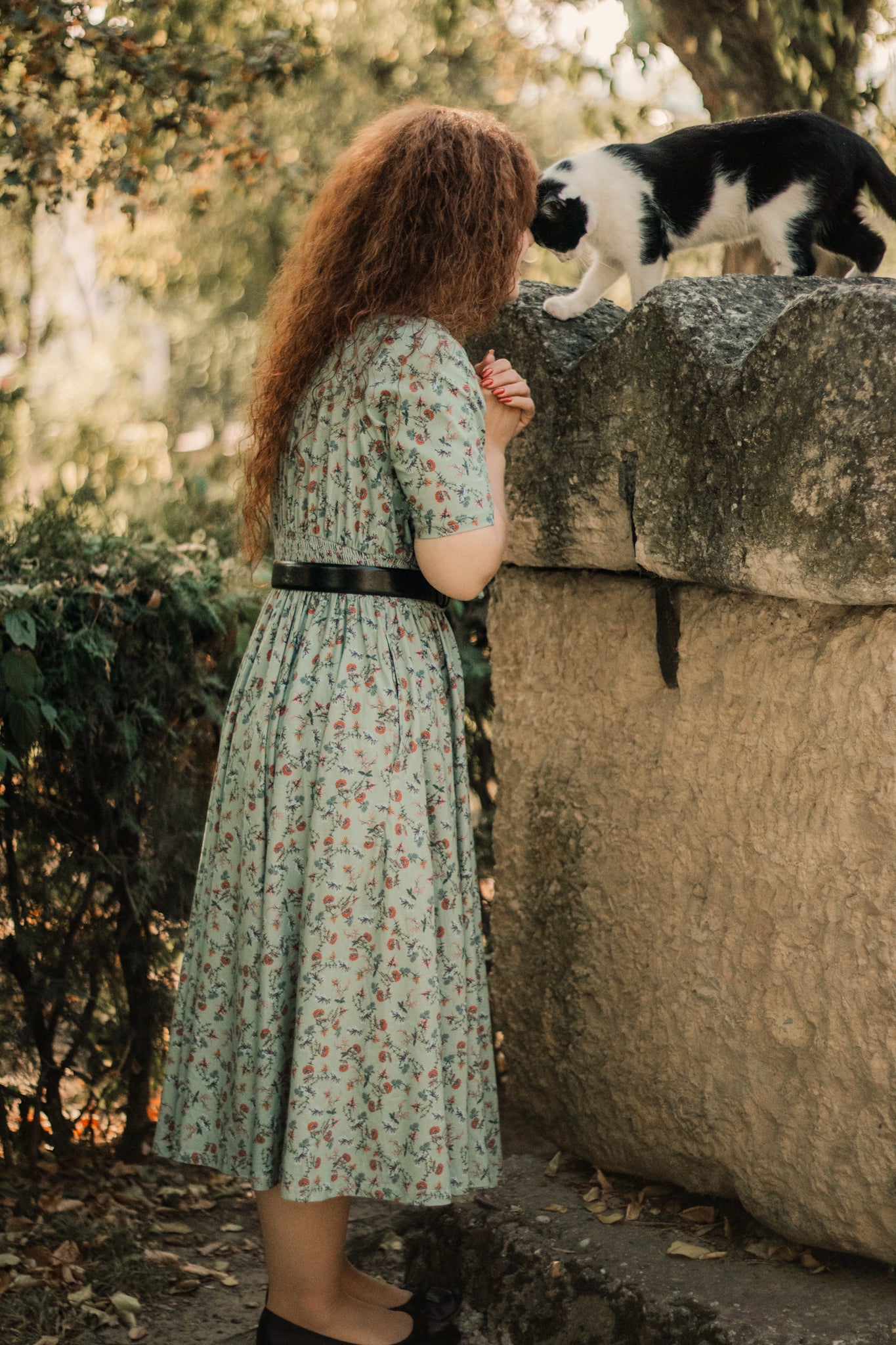 Woman in modest nursing floral dress with cat