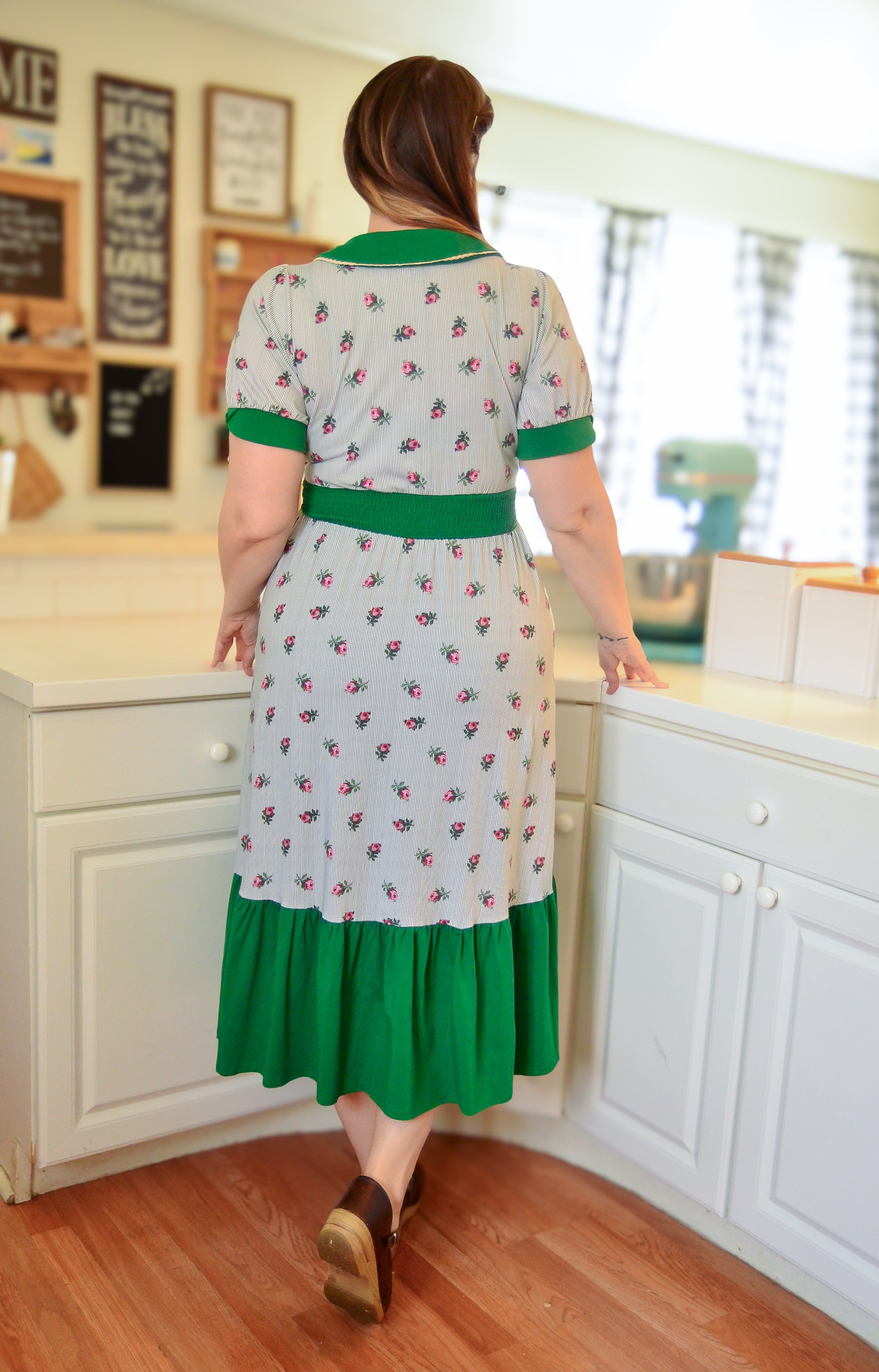 woman wearing a green and white striped modest nursing dress