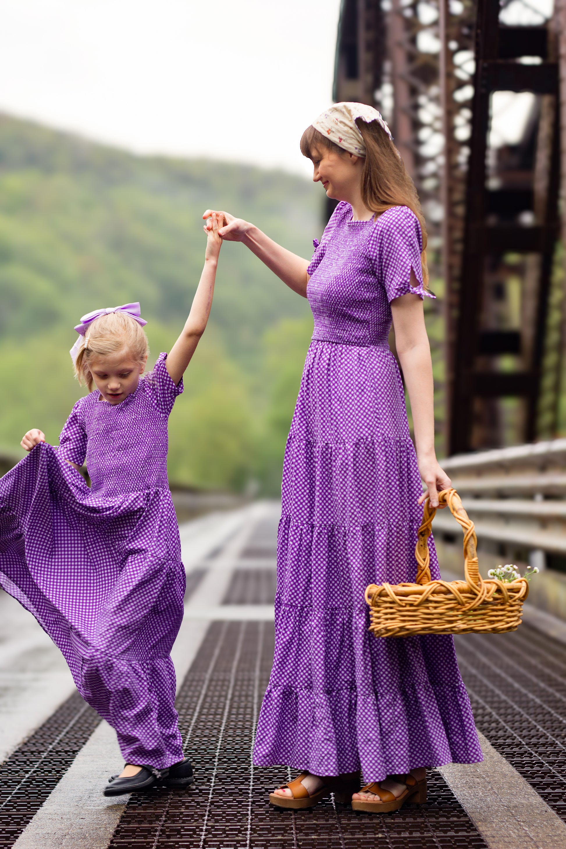 Young girl wearing a modest purple dress with her mother in a modest green nursing dress