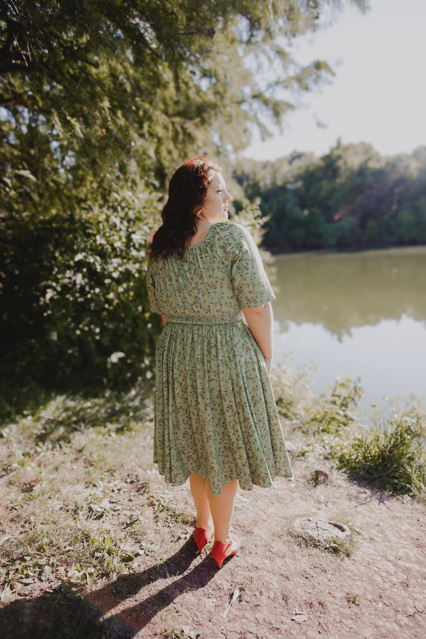 Woman in modest nursing dress by lake