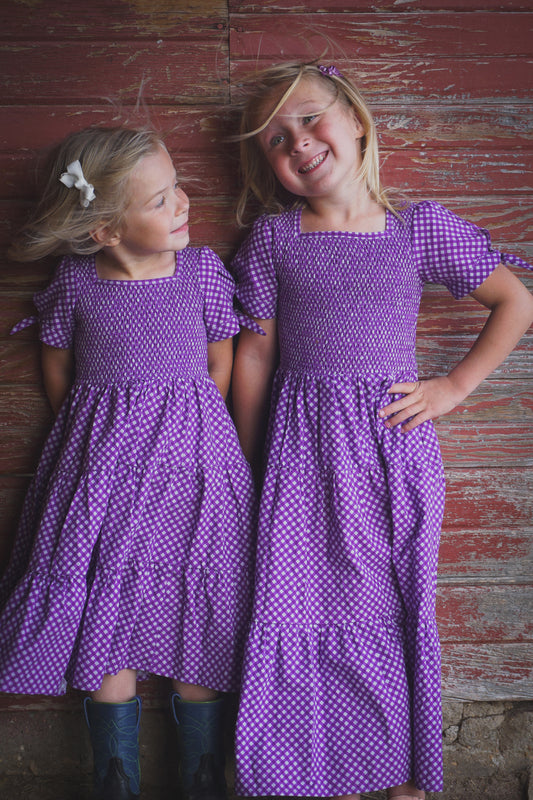 Young girls wearing modest purple dresses