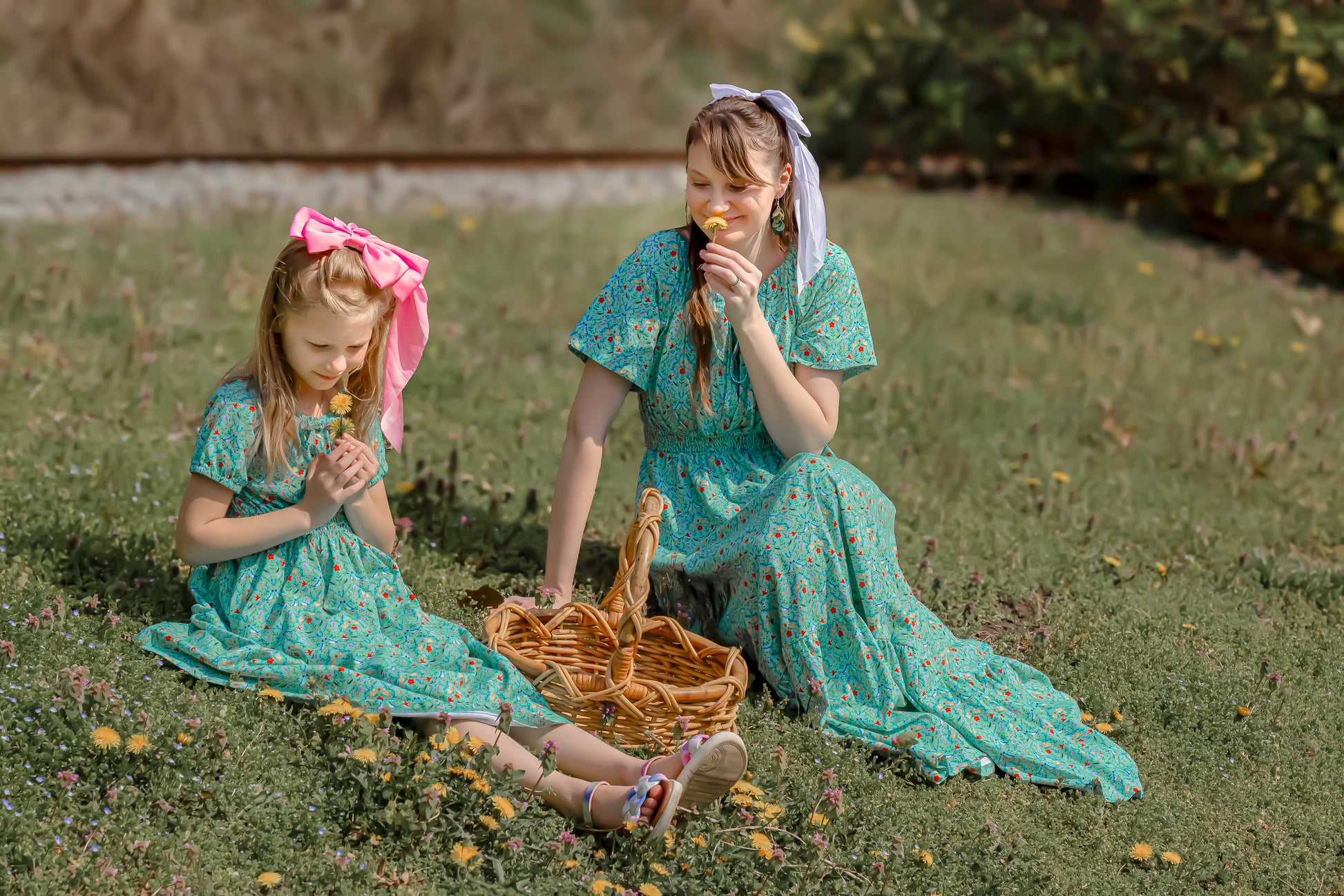 Young girl wearing a modest green dress with her mother in a modest green nursing dress