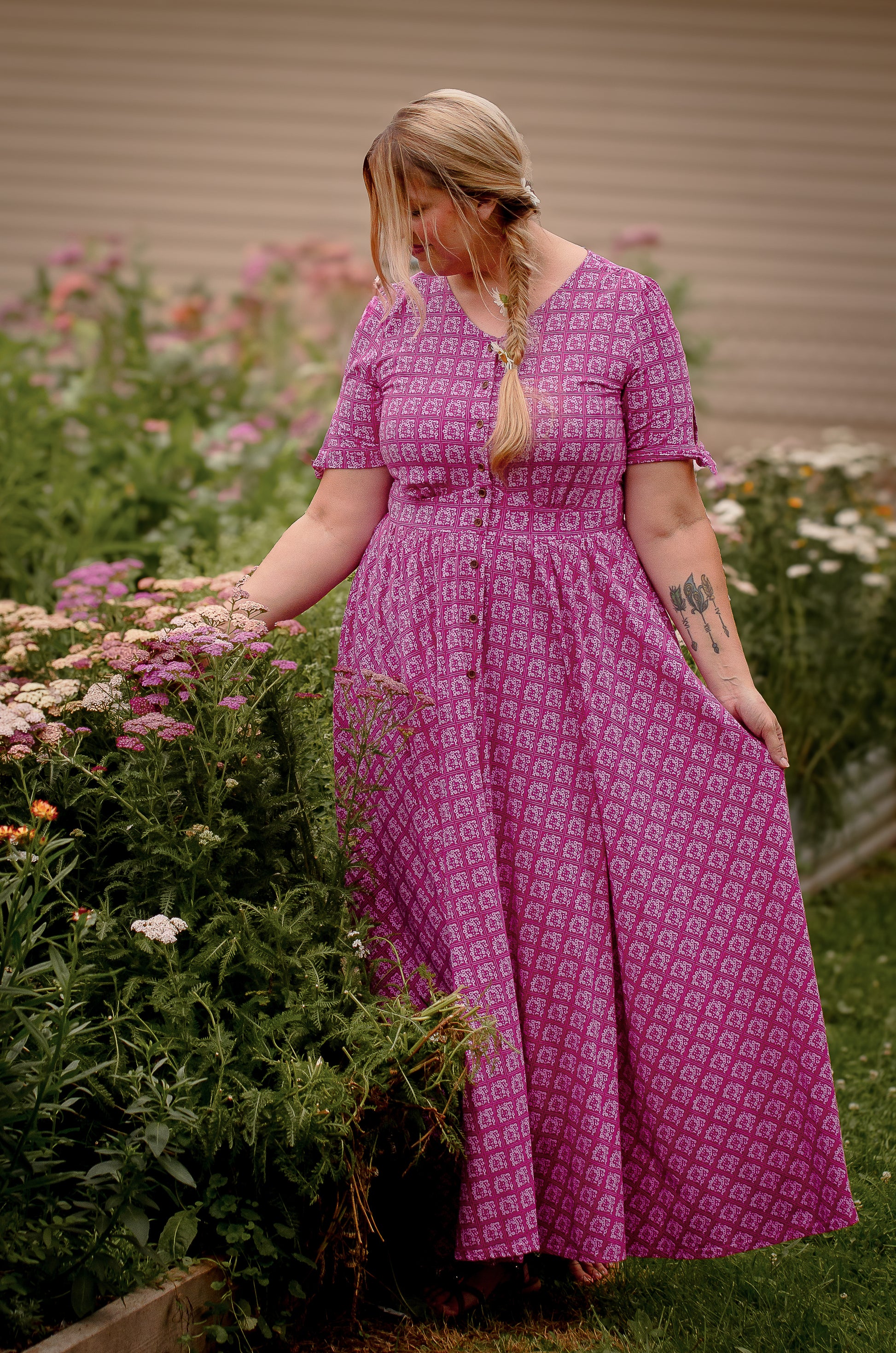 Woman in a purple modest nursing dress standing in a garden