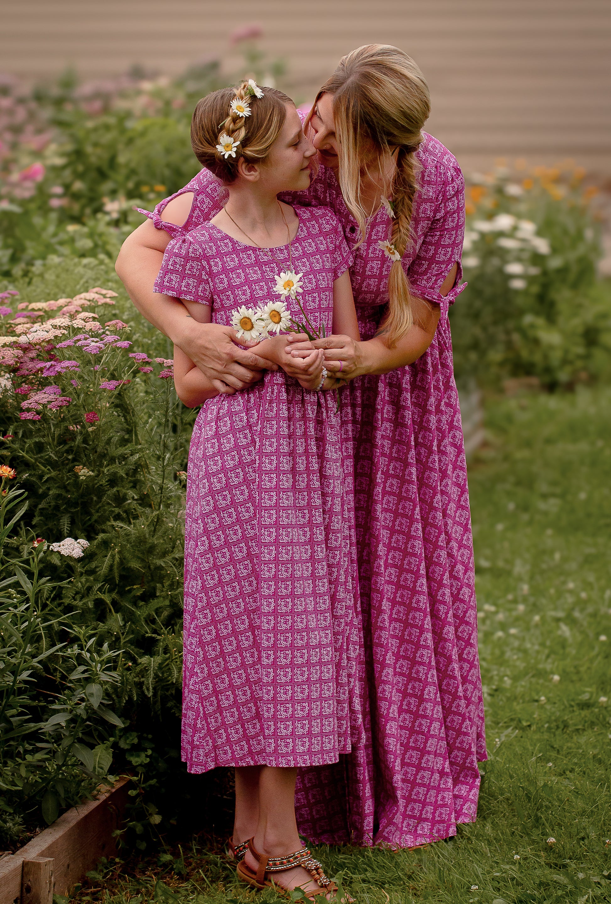 Young girl in a modest pink dress with her mother wearing a modest pink nursing dress