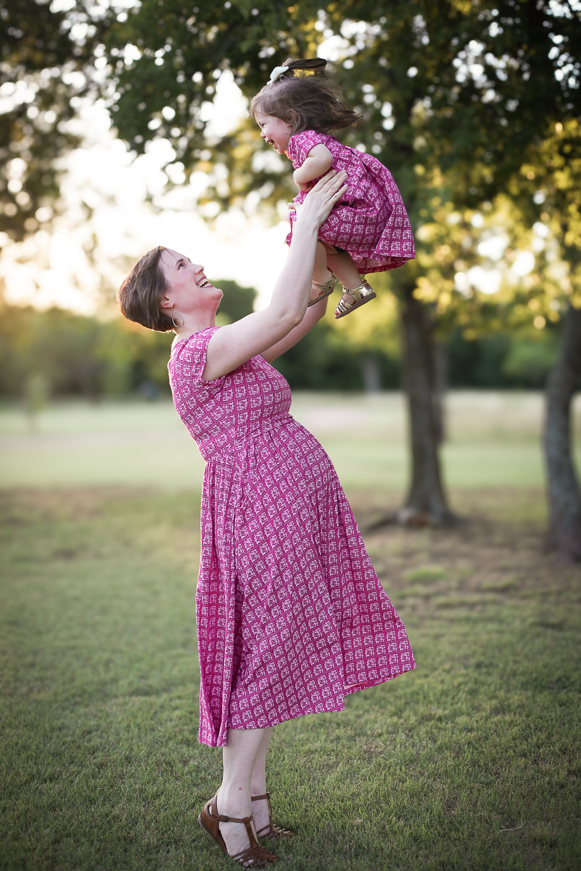 Young girl in a modest pink dress with her mother wearing a modest pink nursing dress