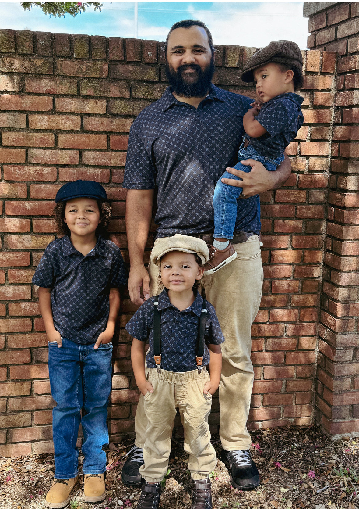 Young boys wearing dark blue polo shirts with their father in a matching shirt