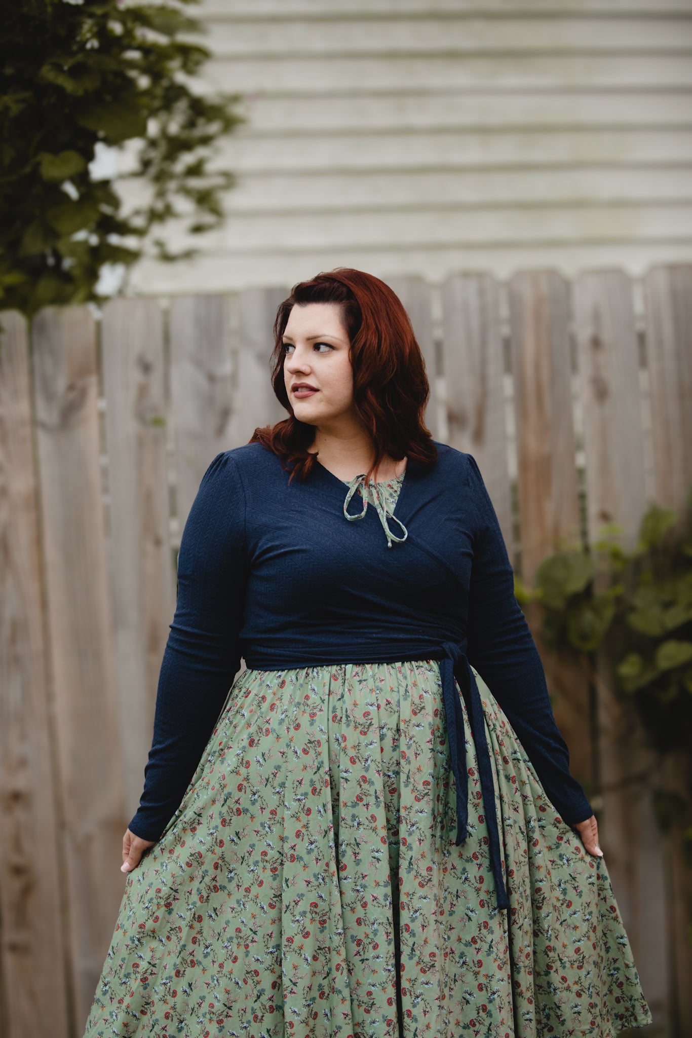 Woman in modest nursing dress by fence