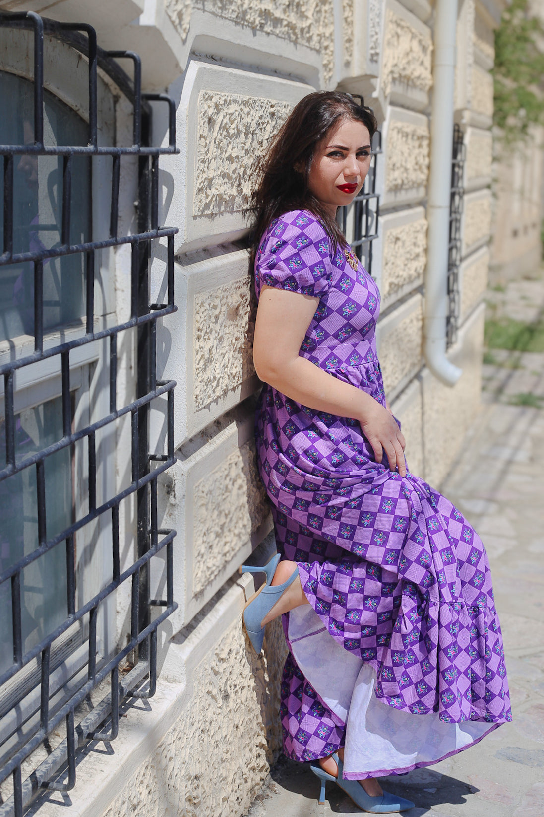 Woman in a purple checkered modest nursing dress.