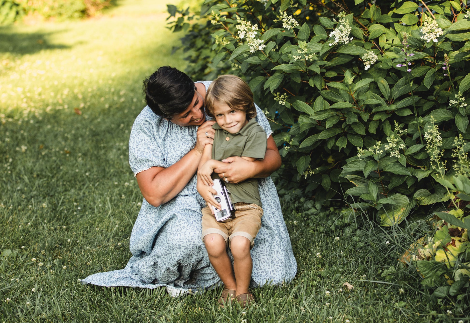 woman in a modest blue nursing dress with her son