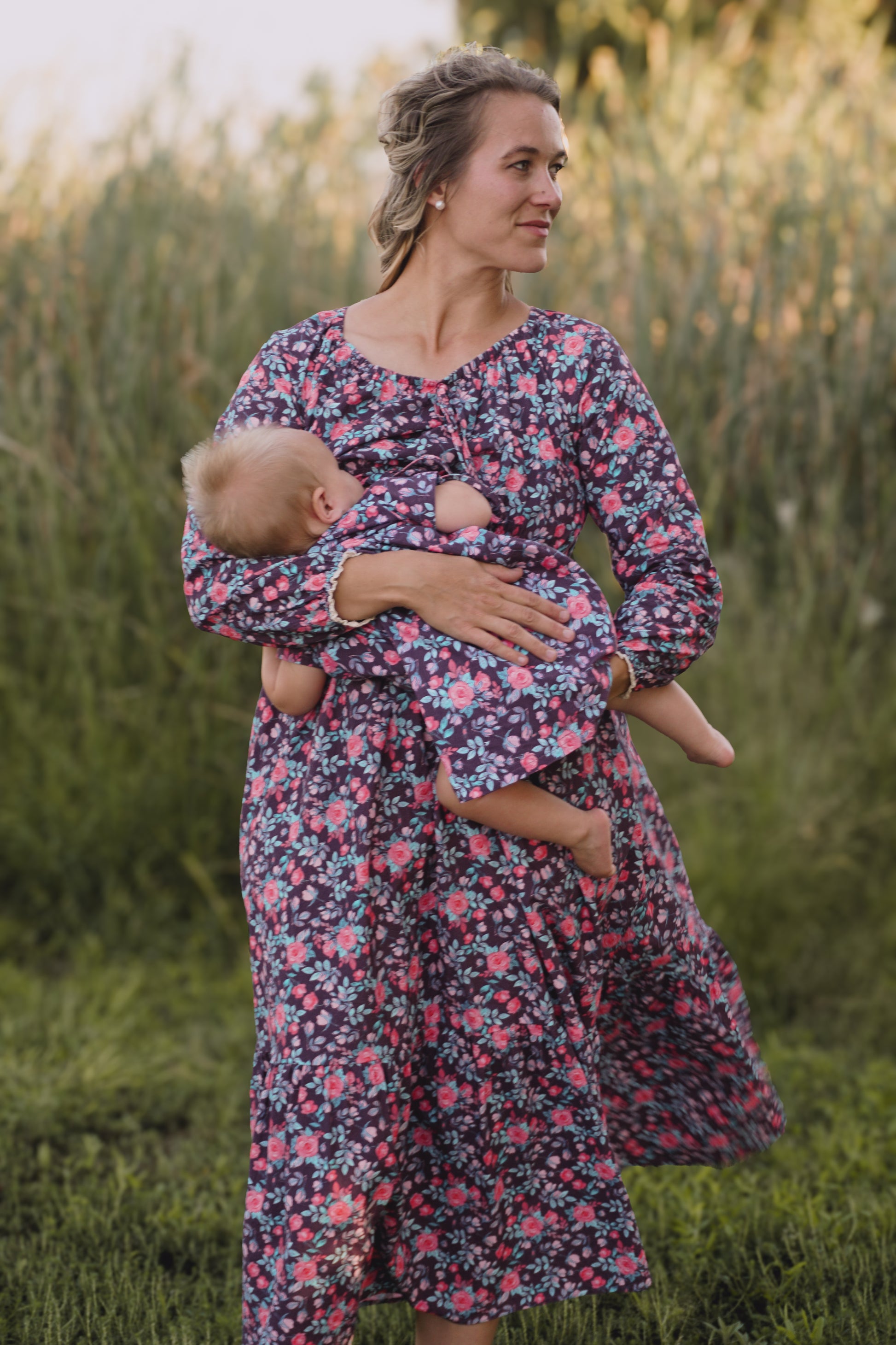 Woman in modest nursing floral dress holding baby