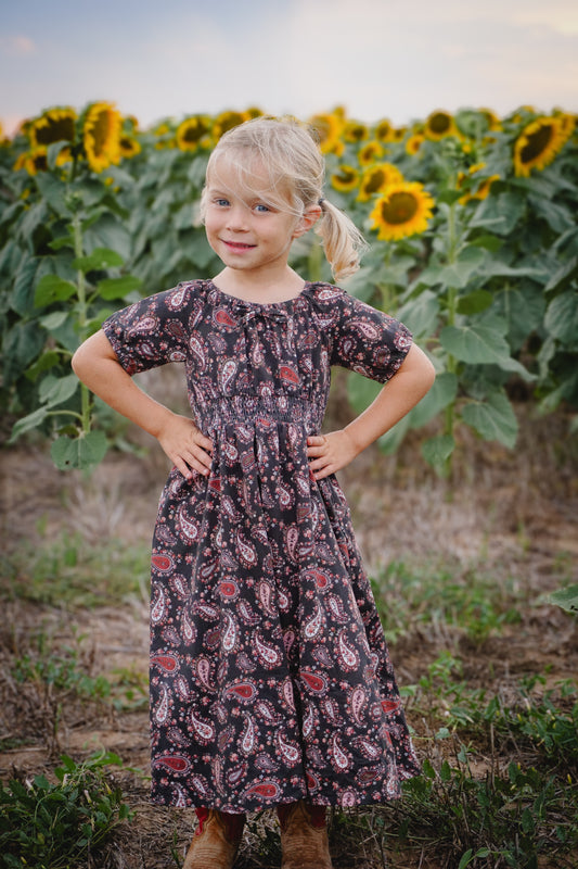 Young girl in floral dress in sunflower field