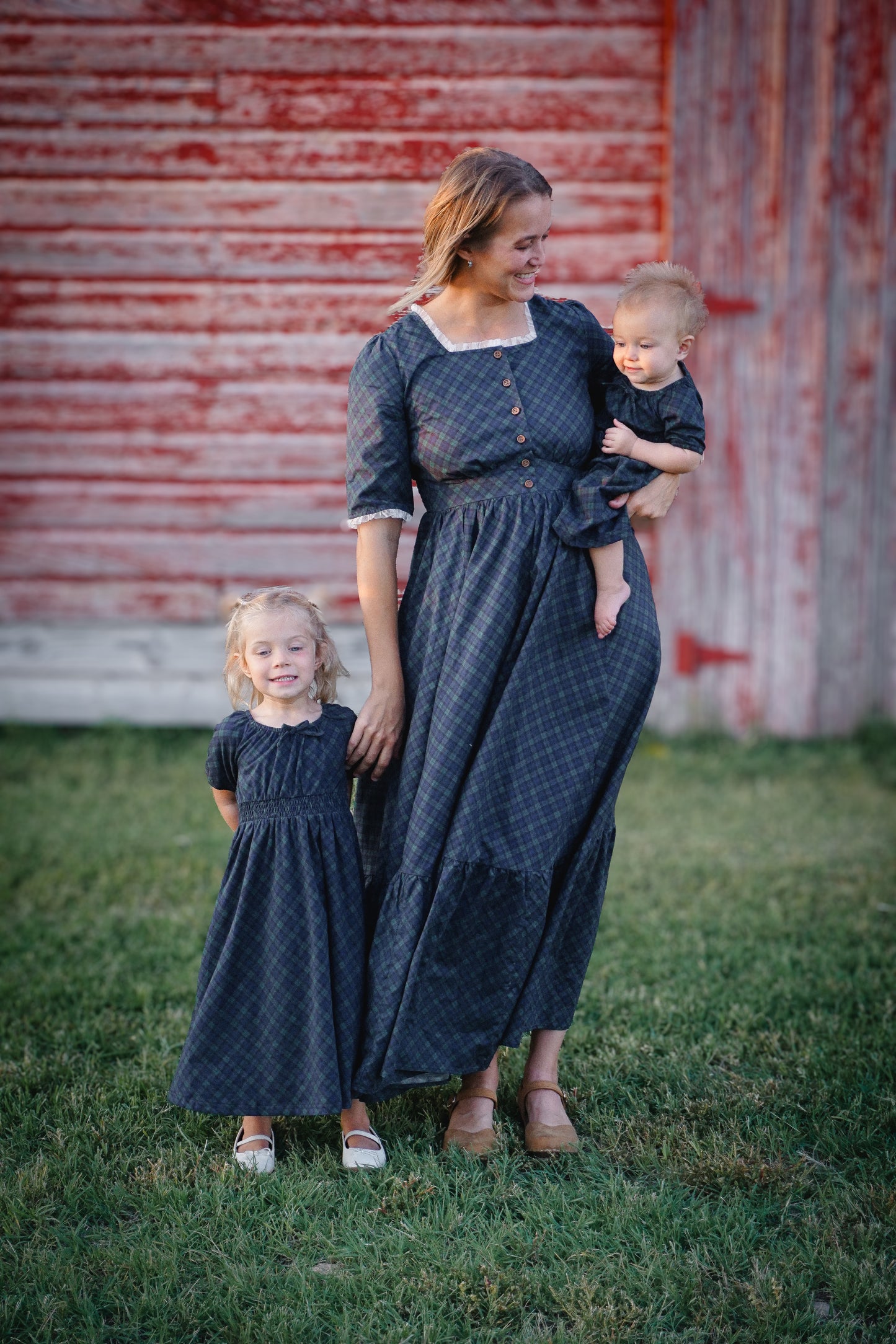 woman wearing a modest nursing blue patterned dress with her daughters wearing matching dresses