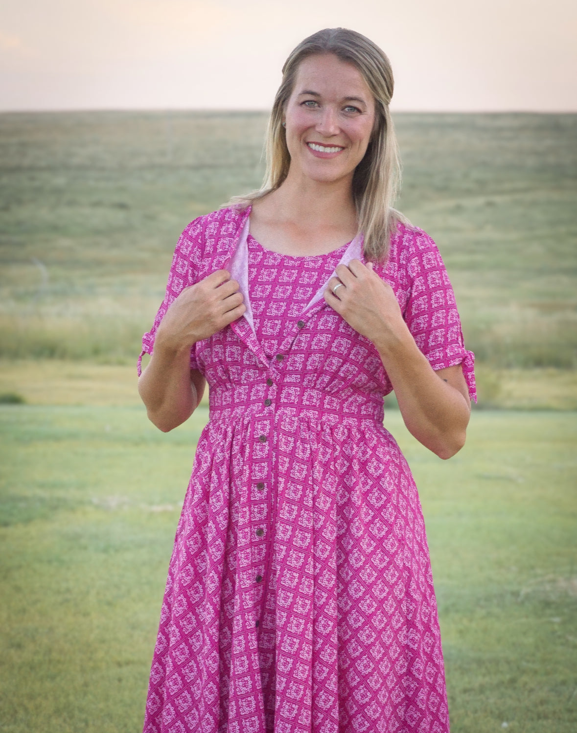 Woman in a pink modest nursing dress standing in a field