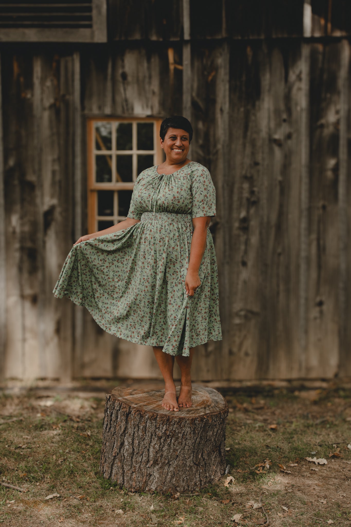 Woman in modest nursing dress outdoors by rustic building