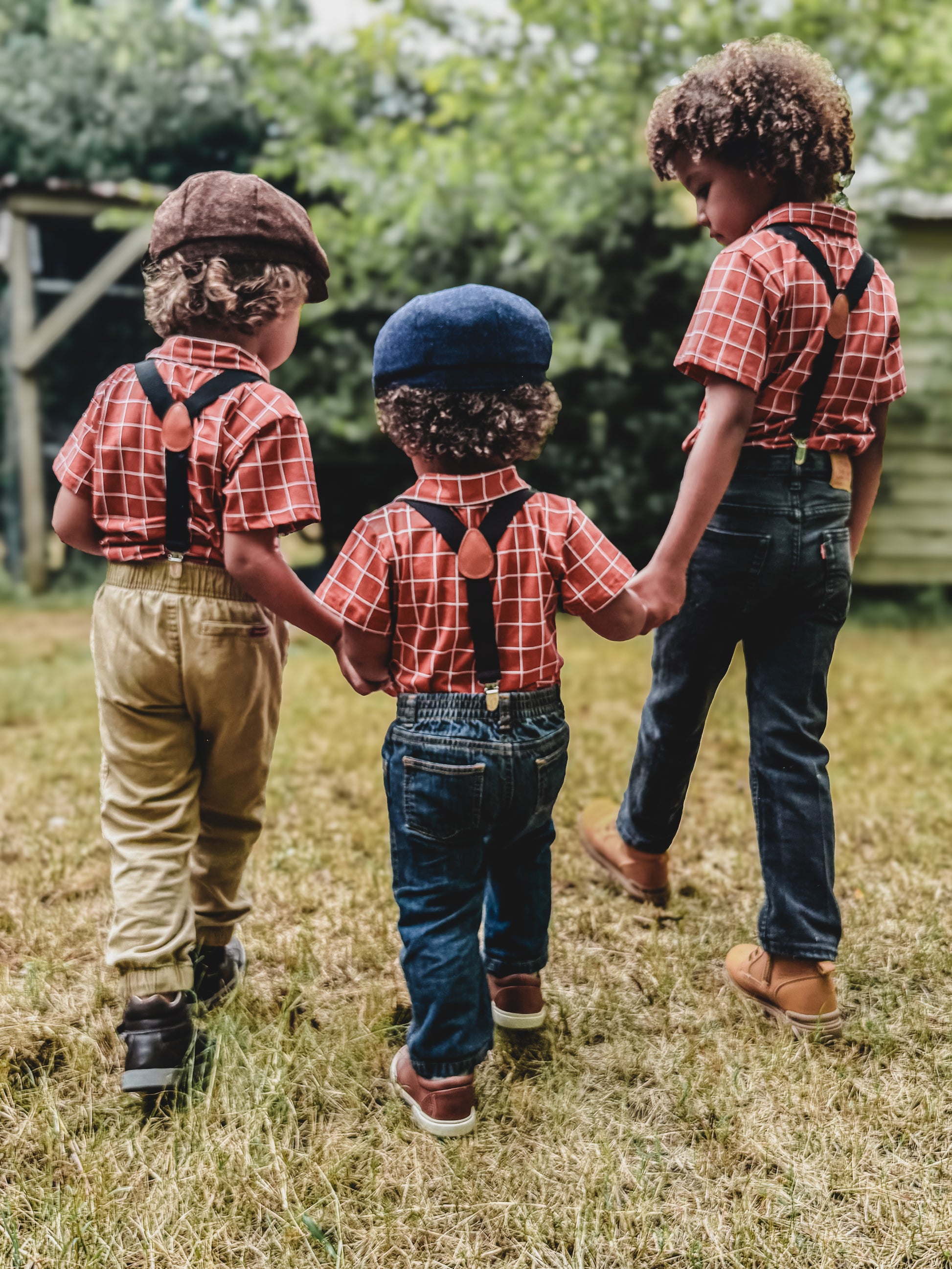 Three boys in plaid shirts and suspenders