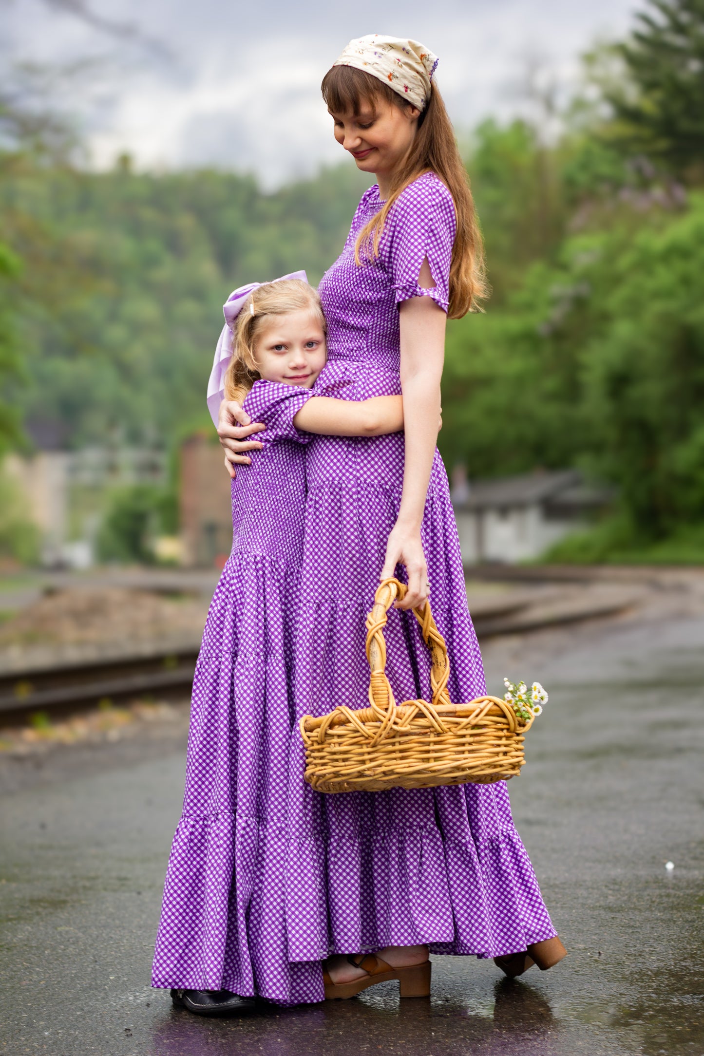 Young girl wearing a modest purple dress with her mother in a modest purple nursing dress
