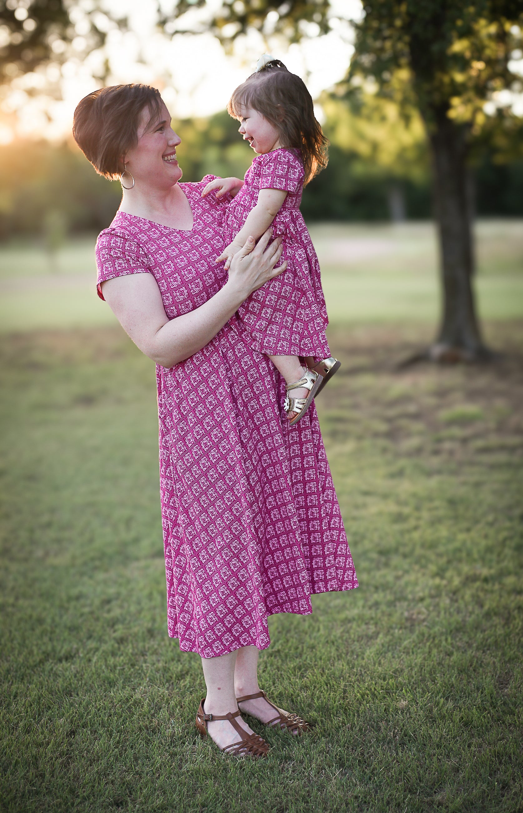 Young girl in a modest pink dress with her mother wearing a modest pink nursing dress