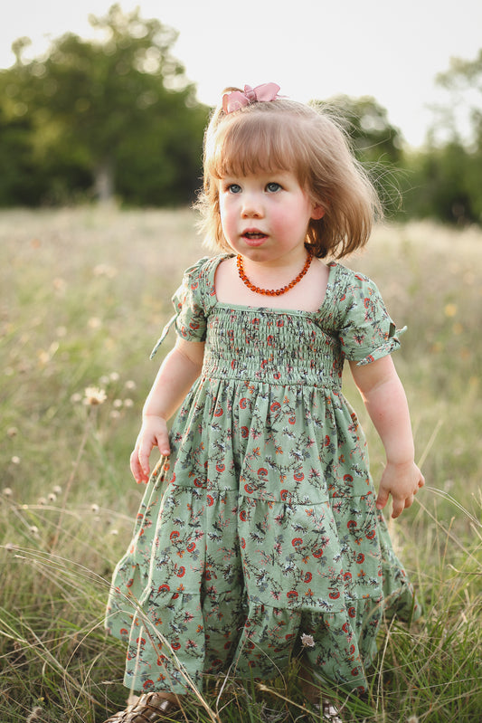 Young girl in a floral dress standing in a field
