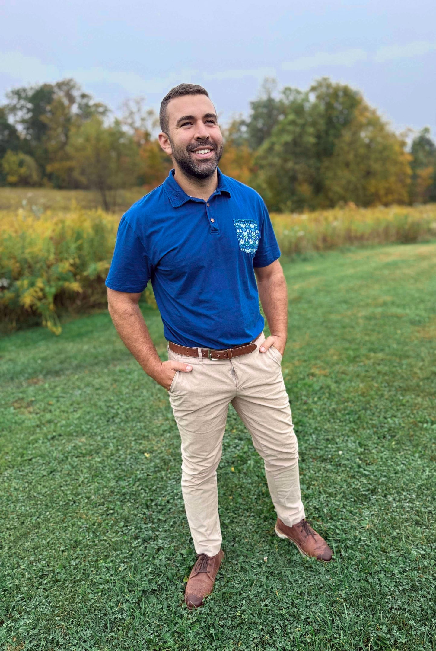 Man in blue polo in field.