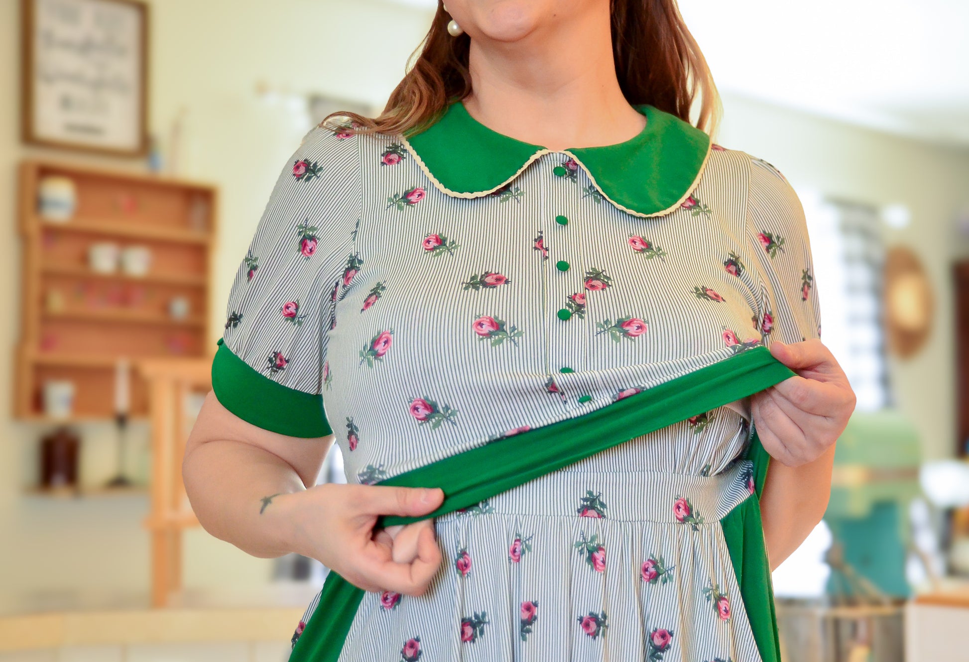 woman wearing a green and white striped modest nursing dress